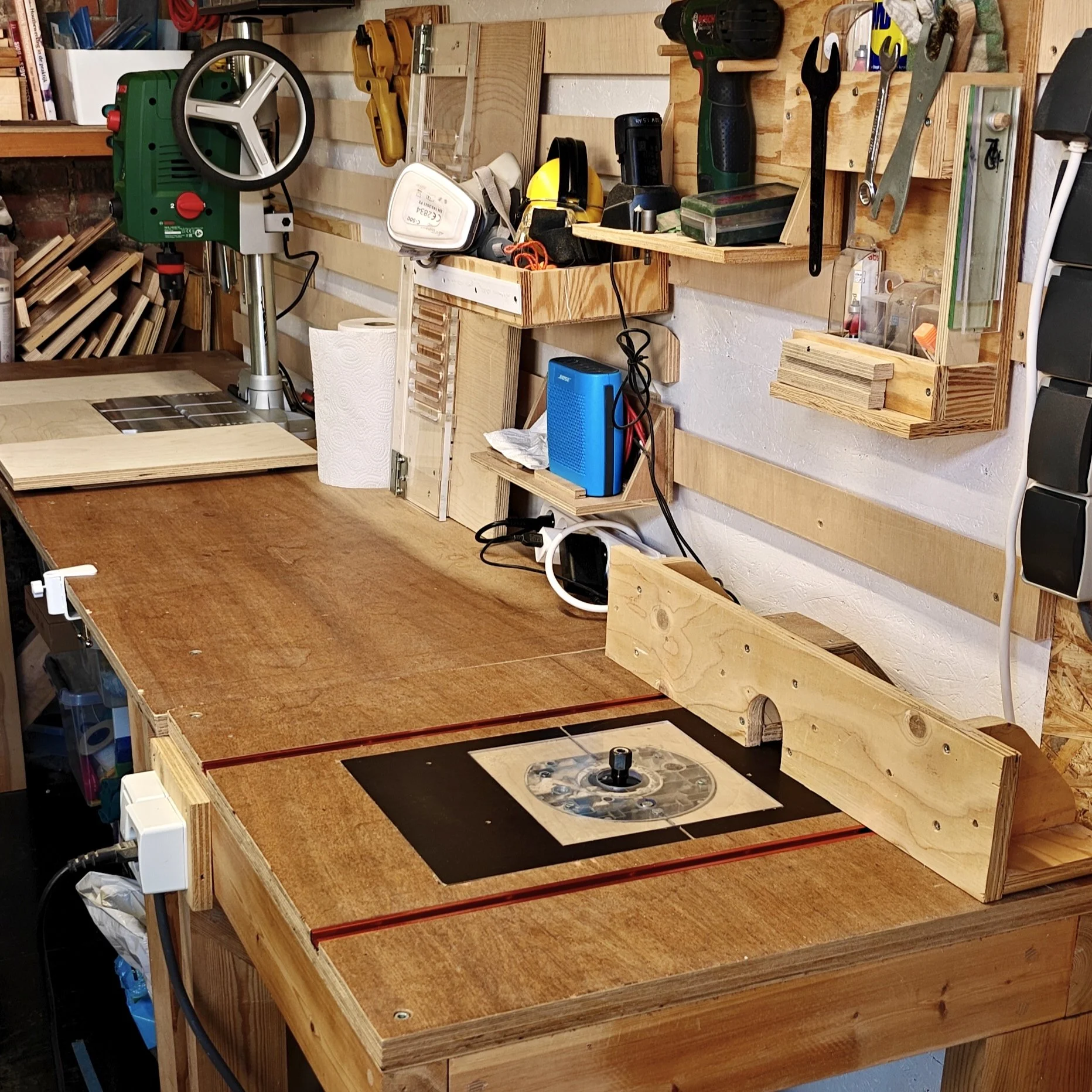 Woodshop wall table with router table, drill press and hand tools storage