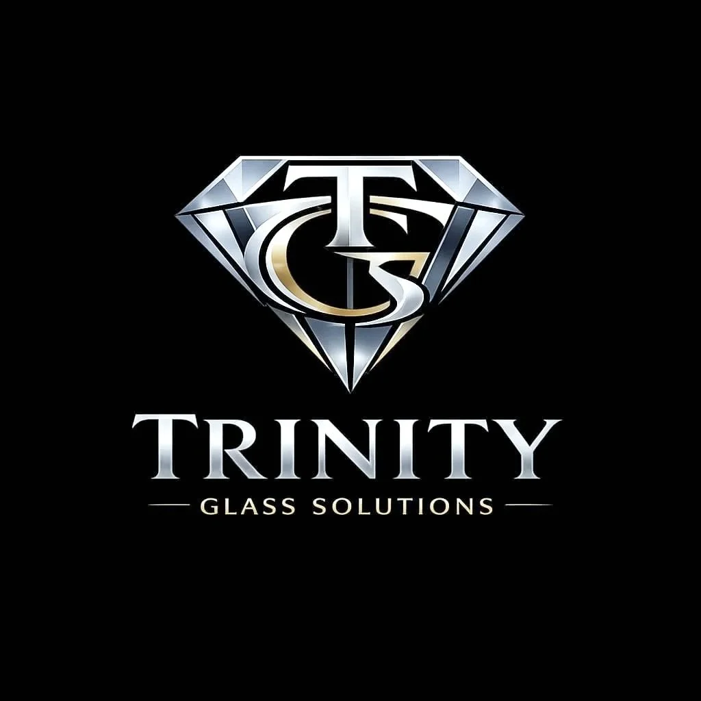 A logo for Trinity Glass Solutions features a stylized diamond with a "T" and "C" inside, resembling a gemstone. The logo is silver and gold on a black background with the words "TRINITY GLASS SOLUTIONS" underneath.