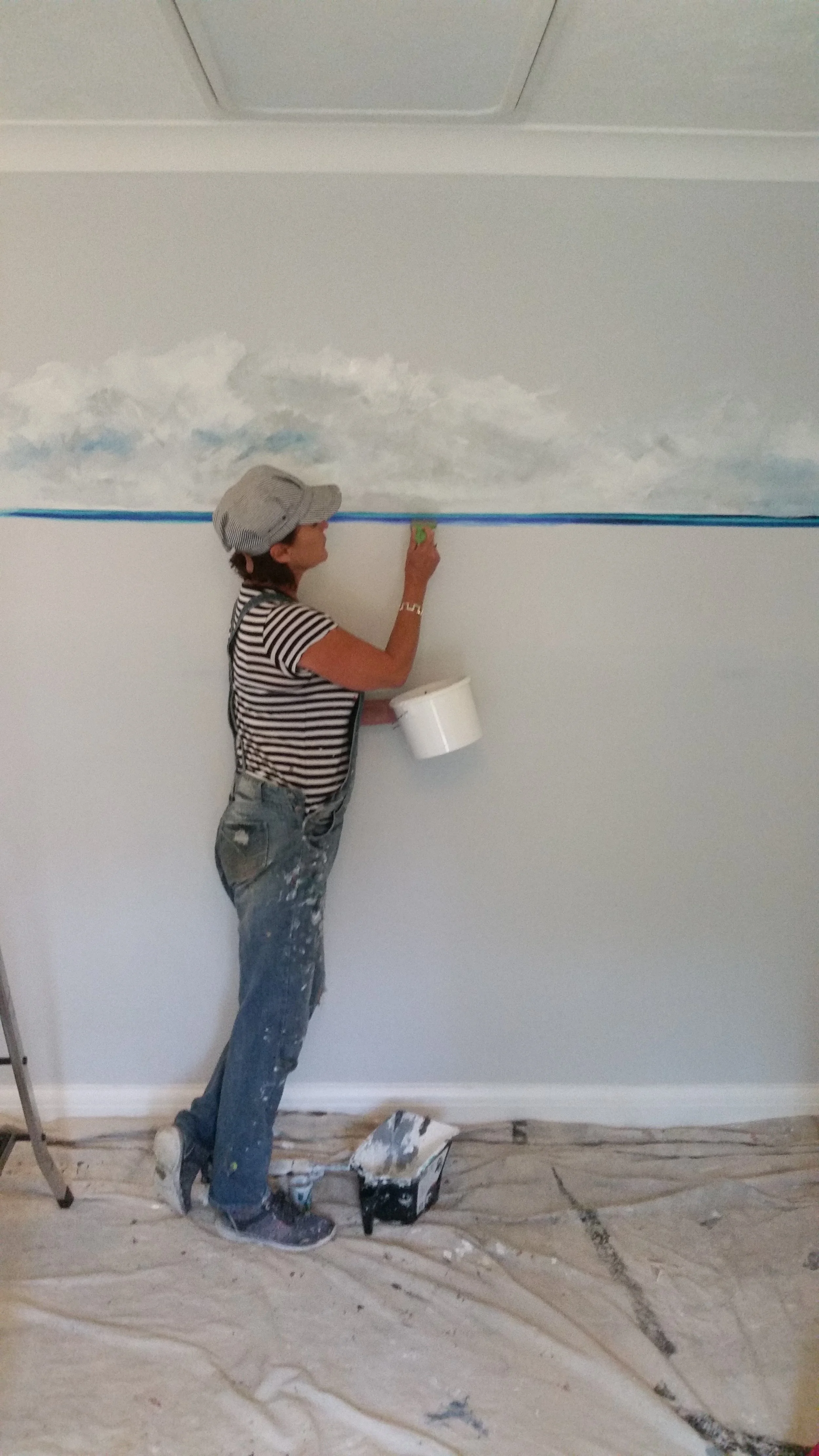 A photo of Helena hard at work on a mural.