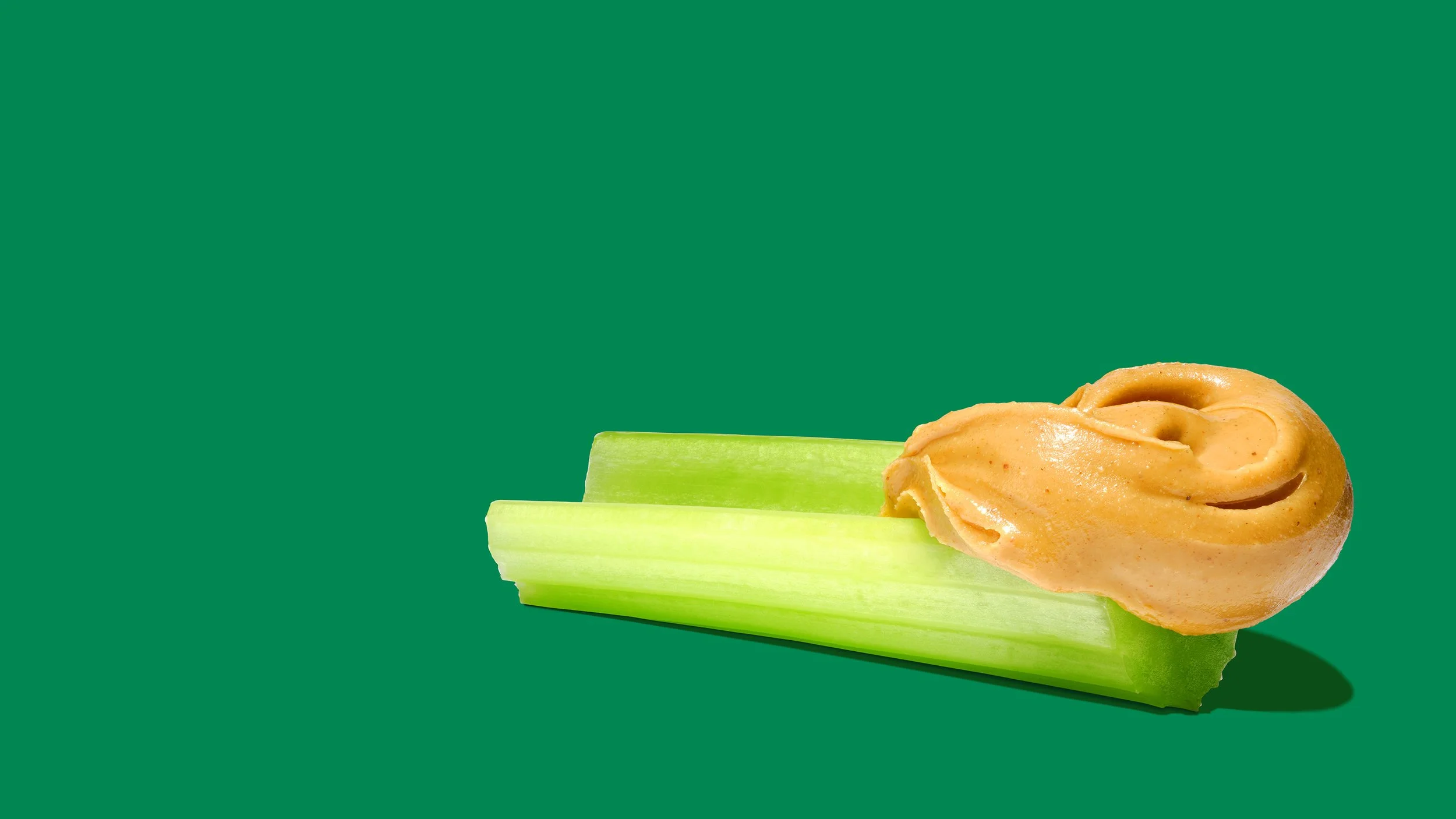 Creamy Peanut Butter on a celery stick, graphic food packaging photography