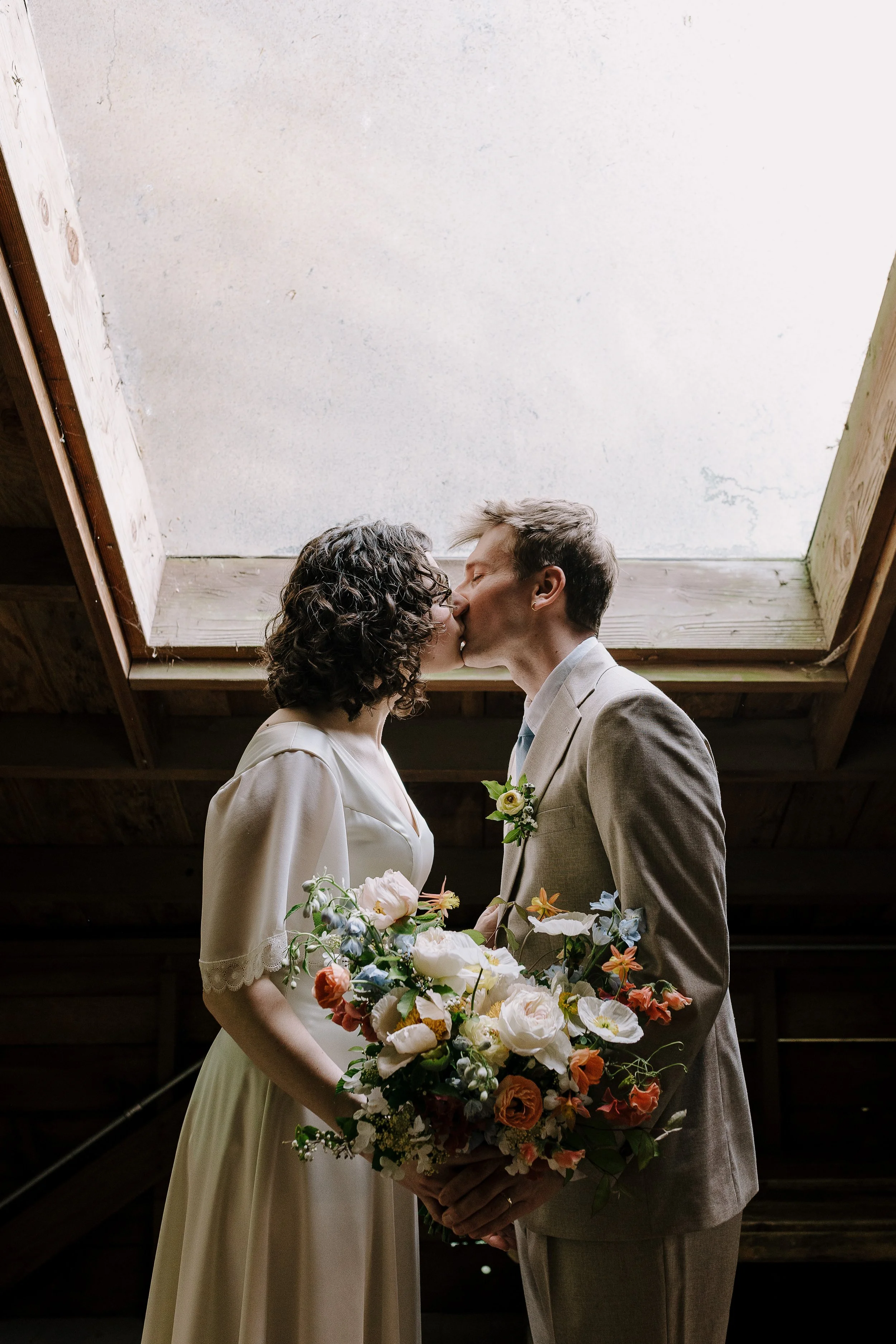 Documentary wedding photography Portland — couple sharing first kiss, natural light, editorial style.