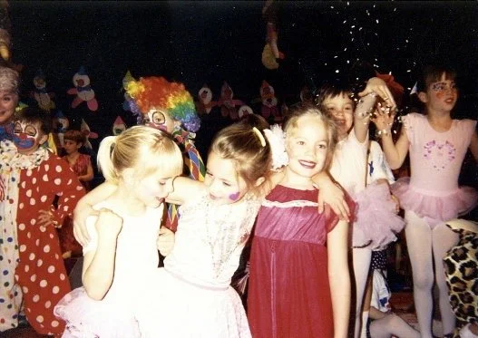 Kids dressed as clowns and princesses celebrating at a party, smiling and playing together.