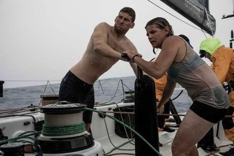Liz Wardley and a crew member working a winch aboard an offshore racing yacht.