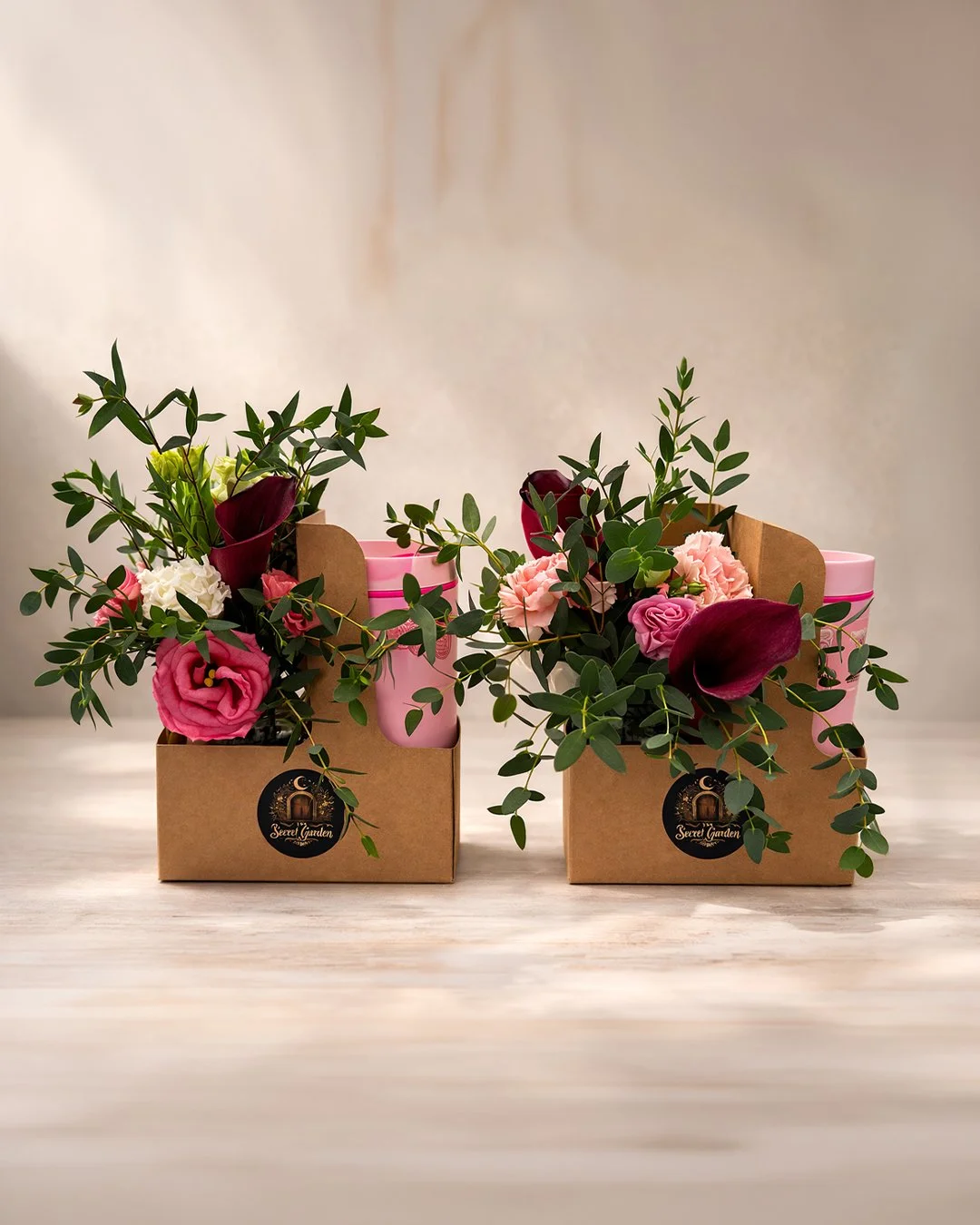 Custom flower arrangements by The Secret Garden florist in Hudson, Massachusetts featuring roses, greenery, and gift boxes.