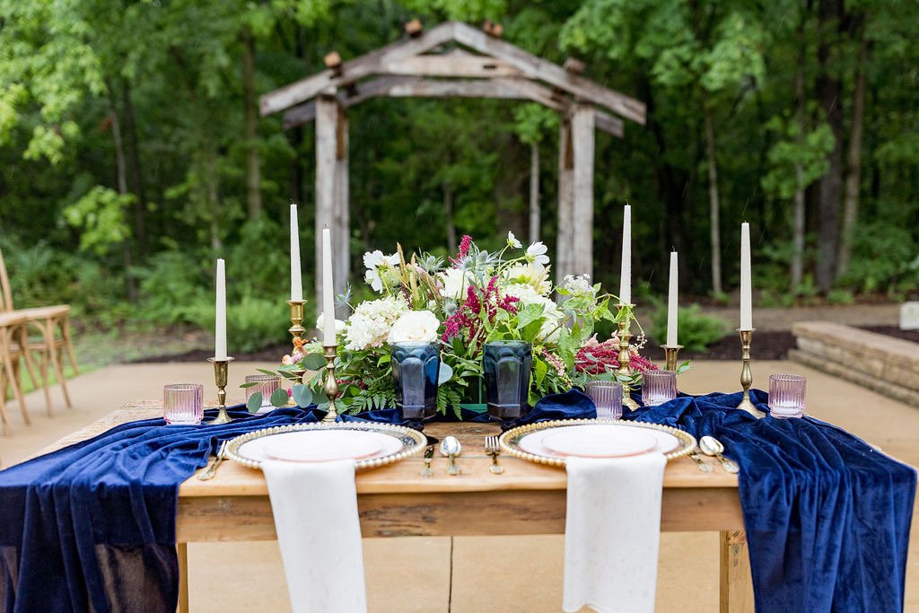 Elegant wedding head table setup outdoor with candles and chargers at 1860 Schulhaus
