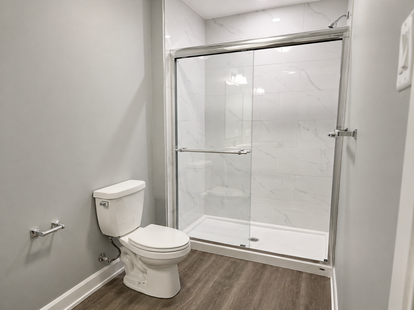 Modern bathroom with a toilet, and glass-enclosed shower.