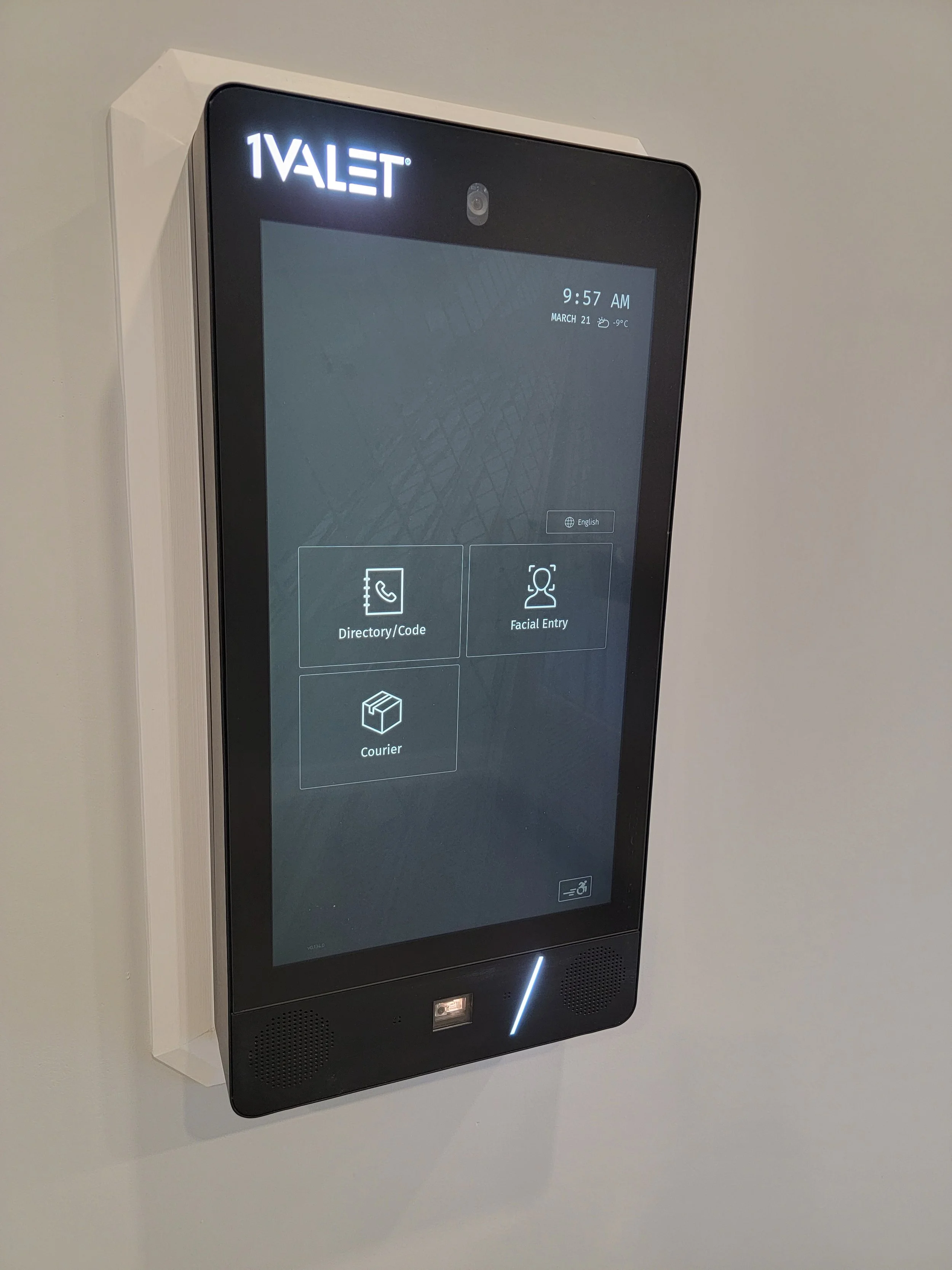 Touchscreen kiosk for hotel check-in with options for Directory/Code, Facial Entry, and Courier, with a white wall background.