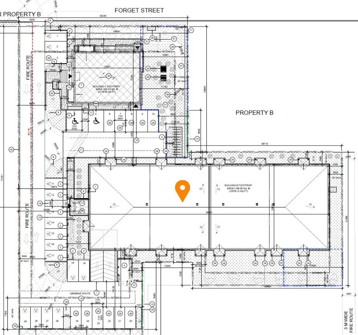 Architectural site plan of a property with building footprints, parking areas, fire routes, landscaping, and various measurements and labels.