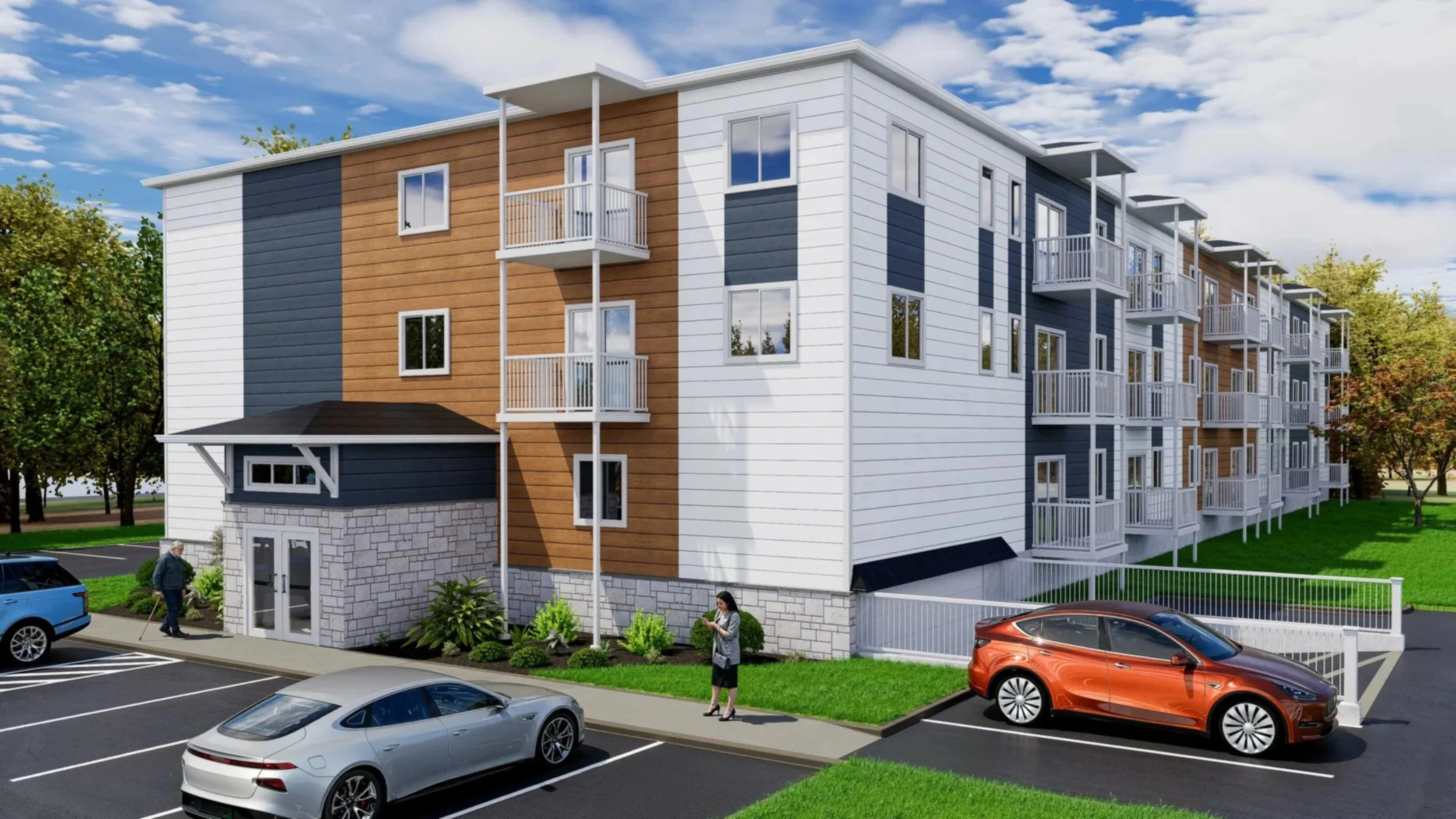 A modern multi-story apartment building with white, blue, and wood exterior siding, featuring small balconies, surrounded by trees, with a parking lot in front and people walking nearby.