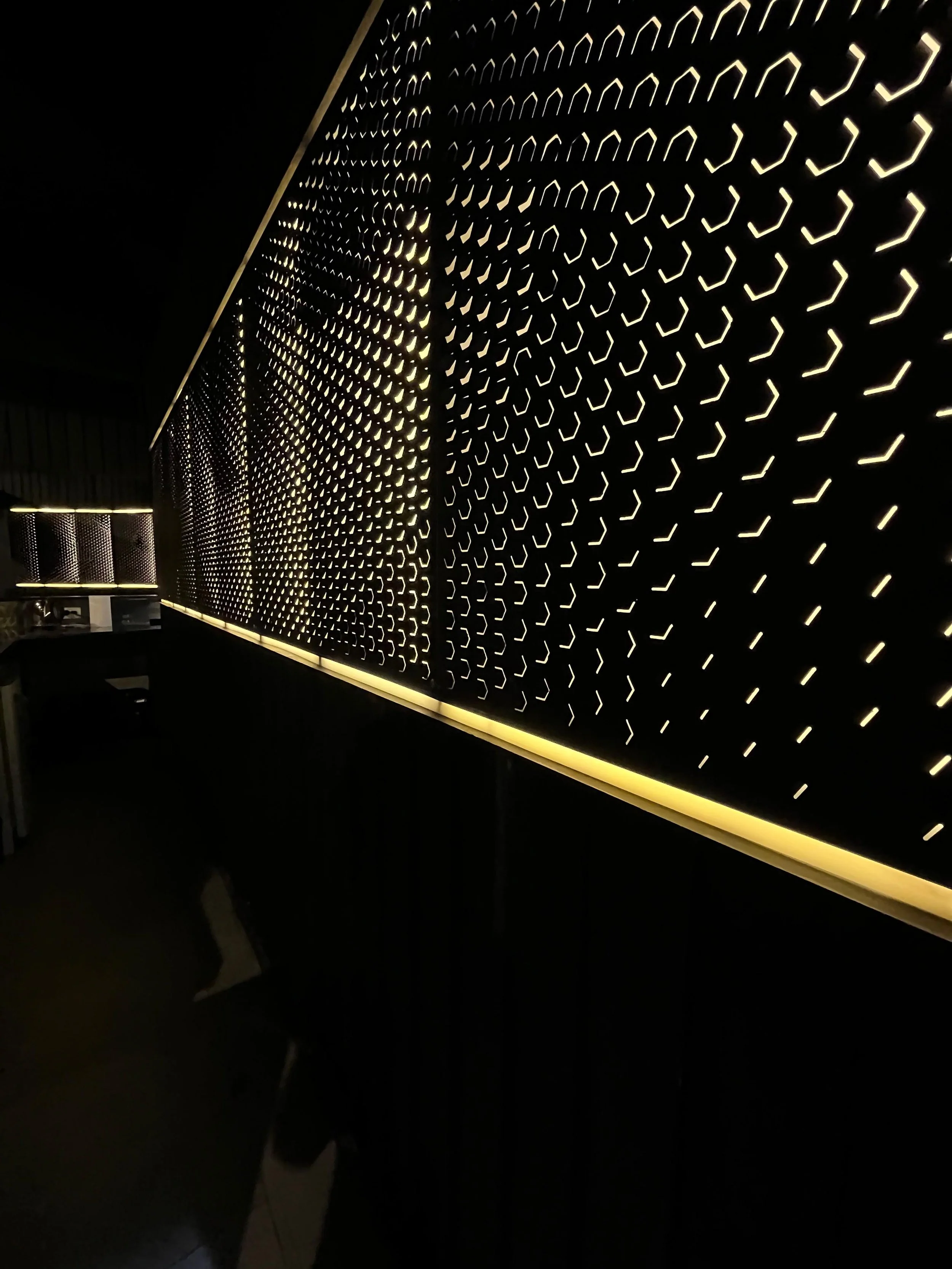 Pared decorativa con patrones de luces LED en un espacio oscuro.