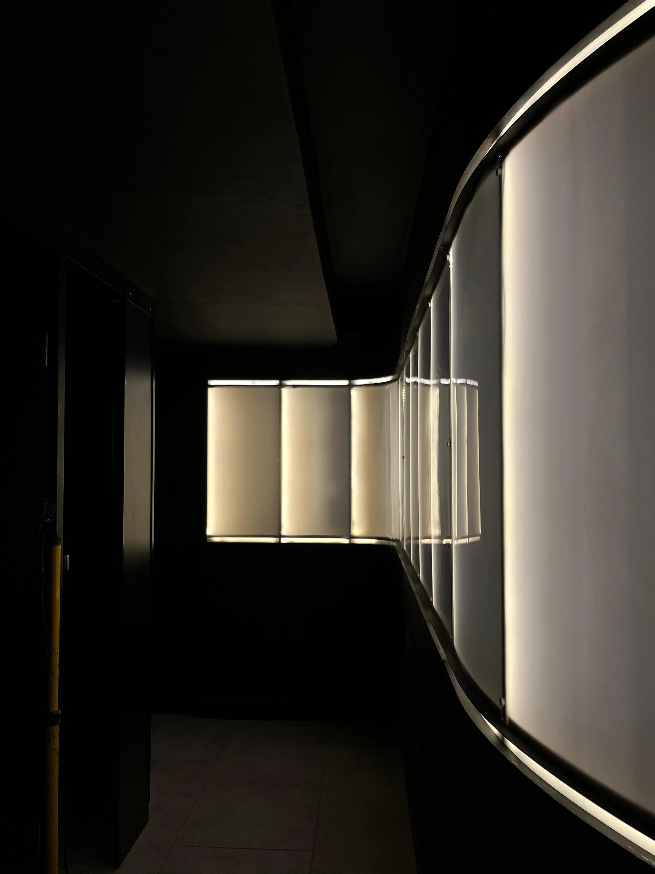 Pasillo oscuro con paredes blancas iluminadas