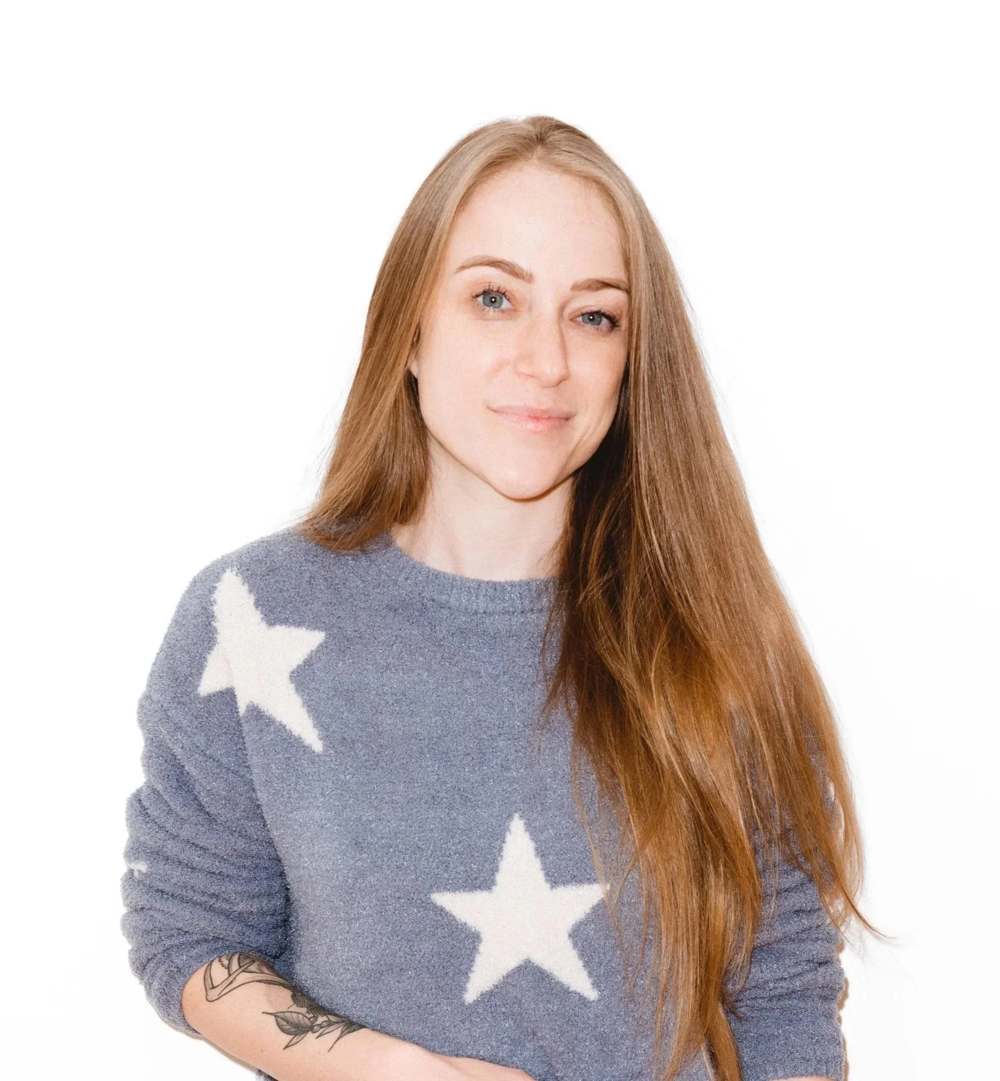 Portrait of Mal, who has dark blonde hair and wears a blue sweater patterned with white stars.