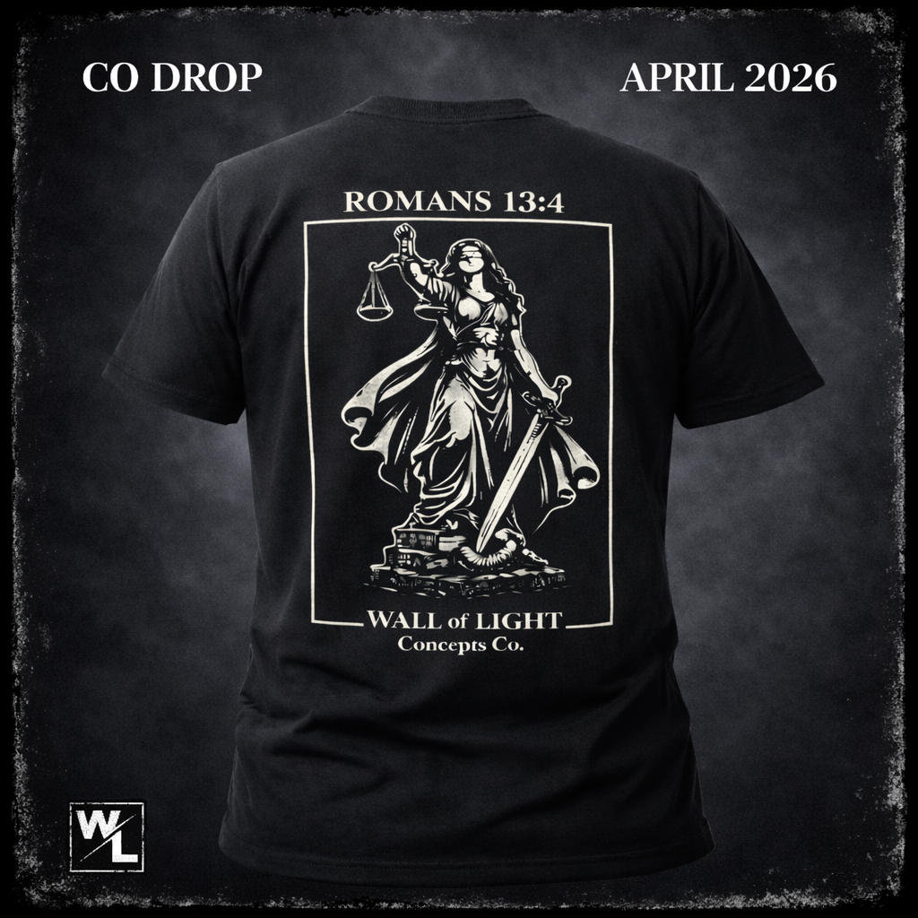 Black T-shirt with a graphic of Lady Justice holding scales and a sword, with the text 'ROMANS 13:4' and 'WALL of LIGHT Concepts Co.', displayed against a dark background. The top corners have the text 'CO DROP' and 'APRIL 2026'.