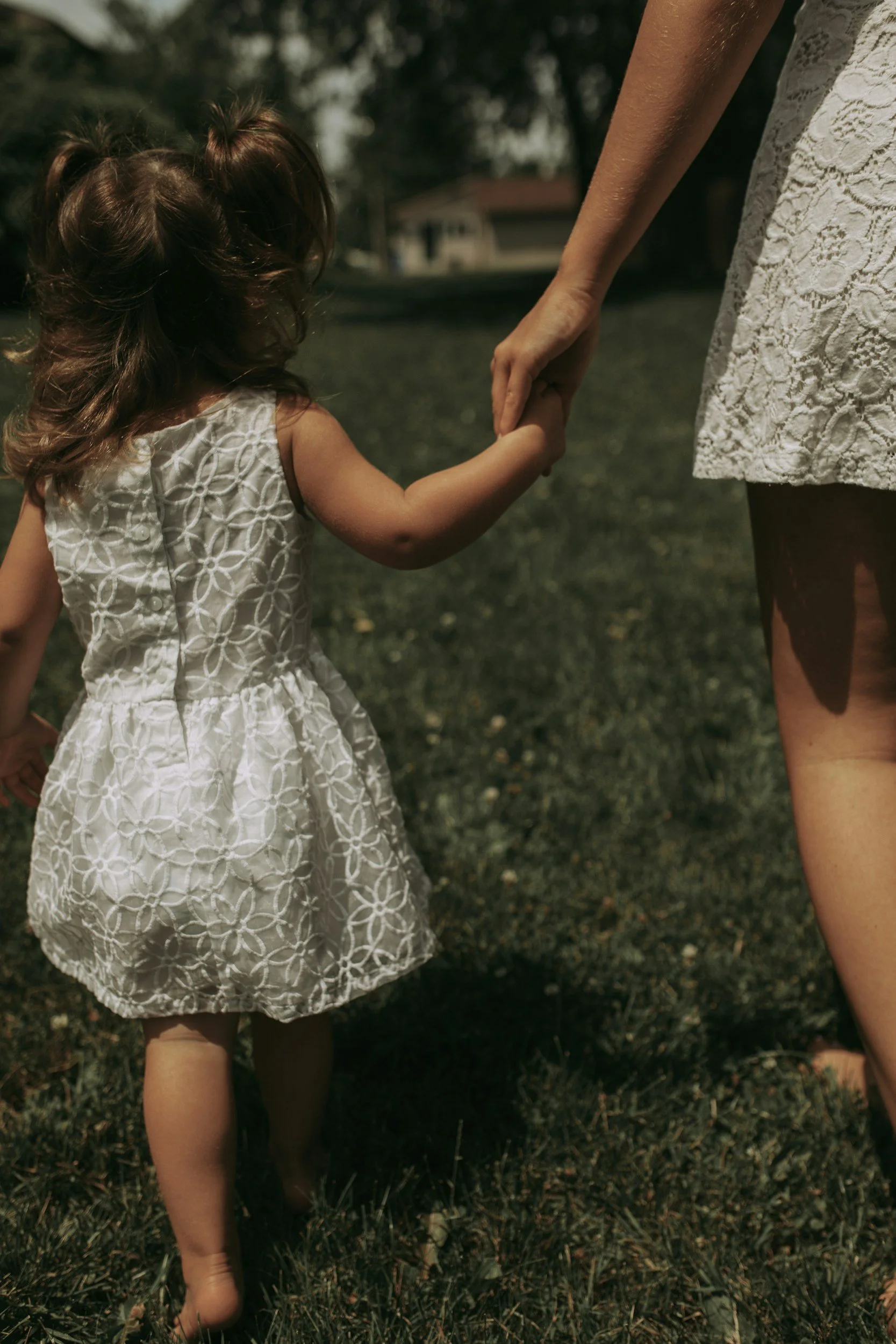 Adult and child holding hands outdoors