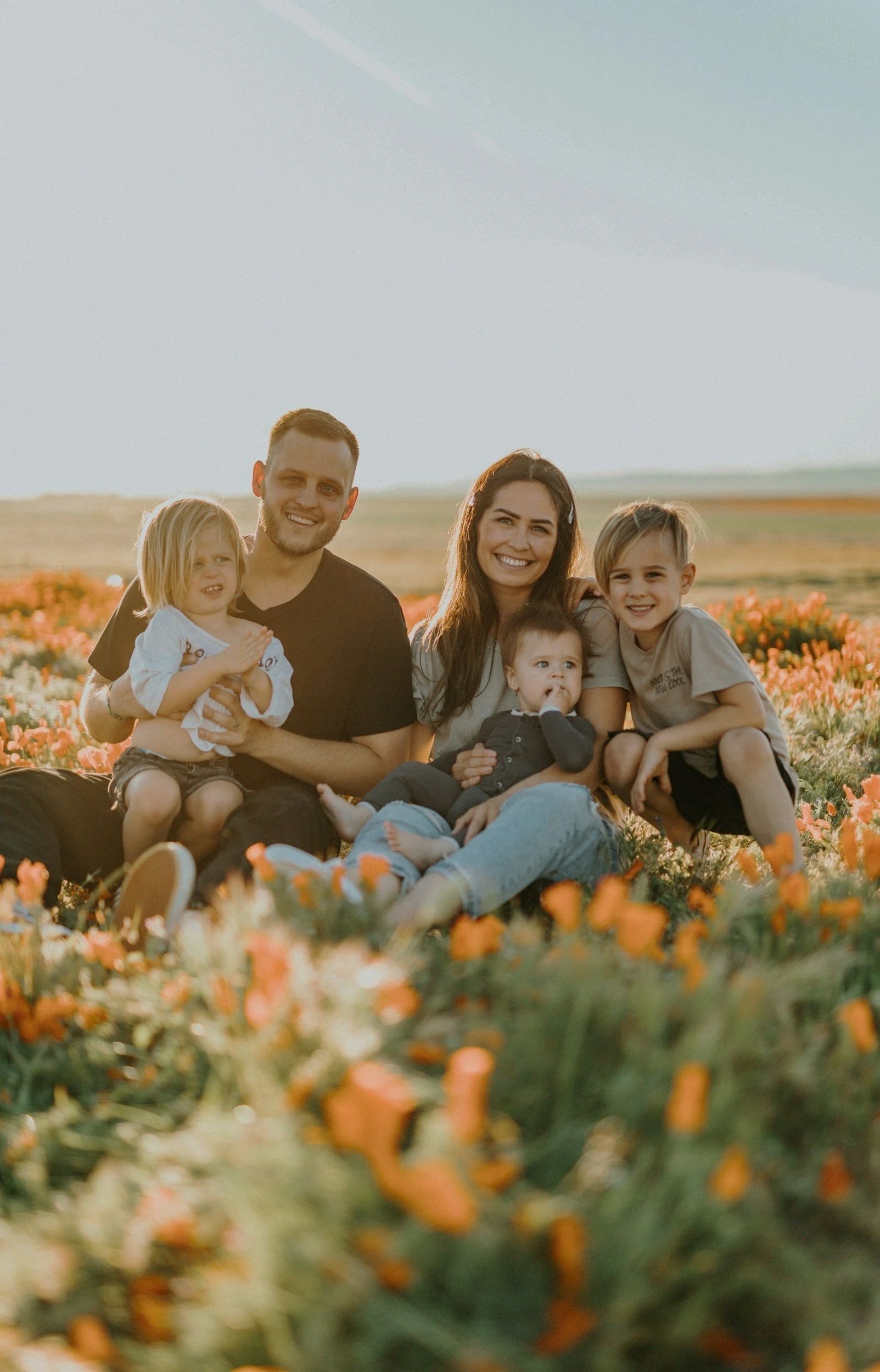 A family of six enjoying time together in a flower field