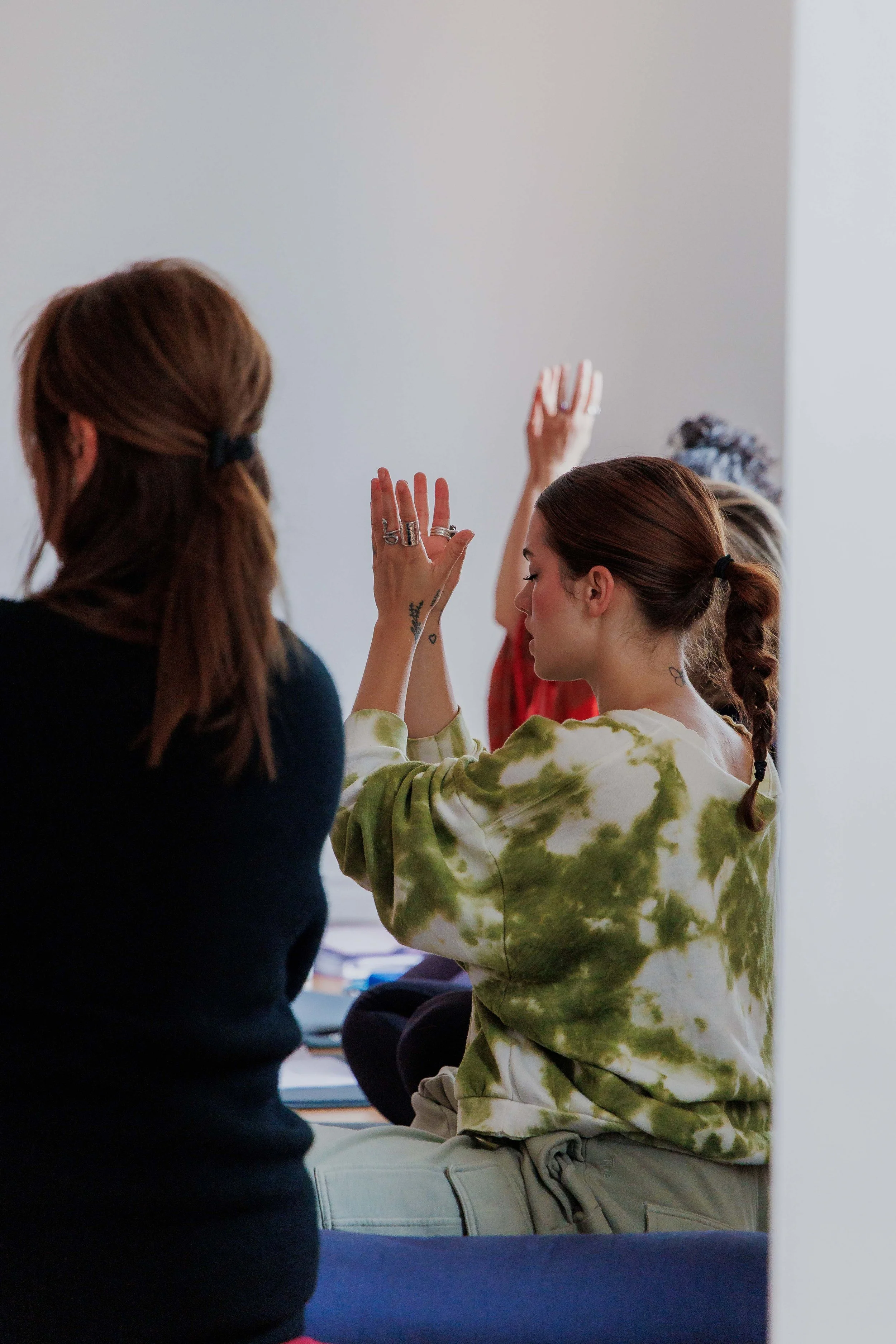 Students practicing kundalini lotus mudra while seated in circle
