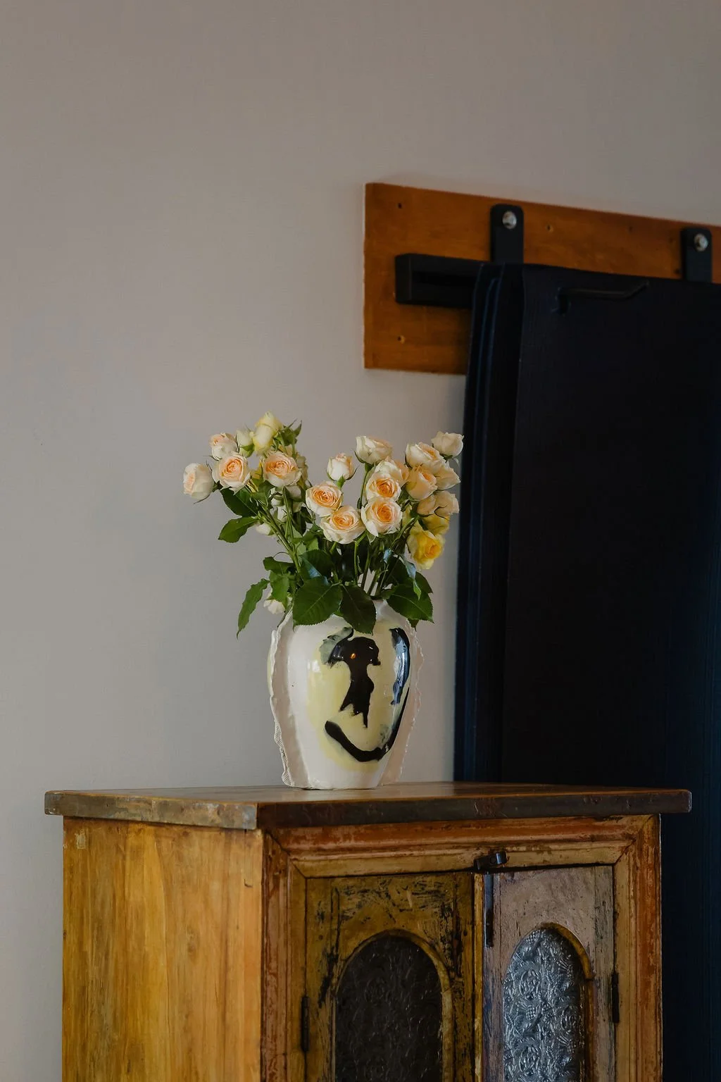 flowers in a handmade vase next to yoga mats