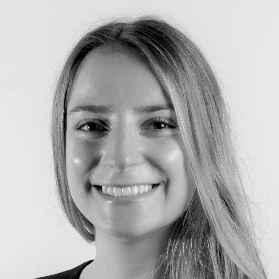 Black and white close-up photo of a smiling woman with shoulder-length hair.