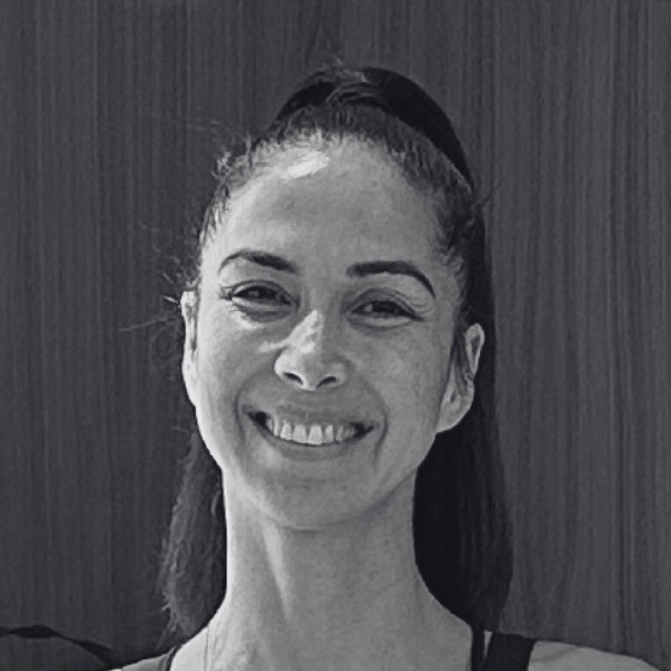 Black and white portrait of a woman with glasses, smiling, with short hair and makeup.