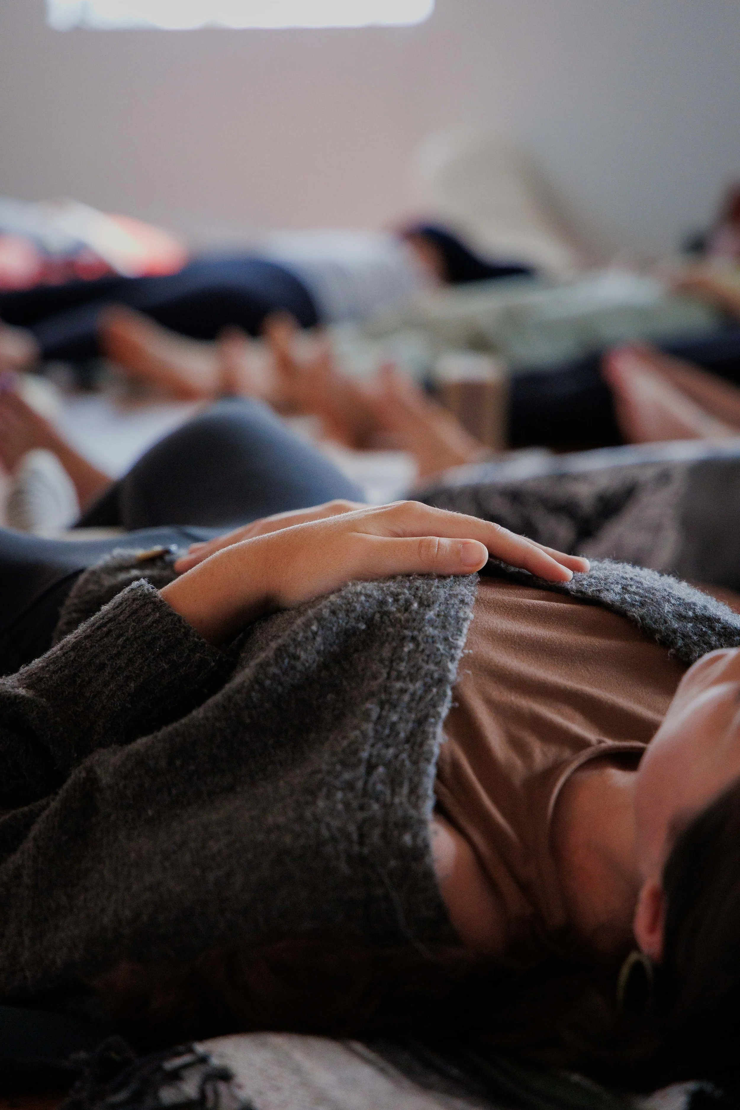 Woman resting in savasana with hand on heart