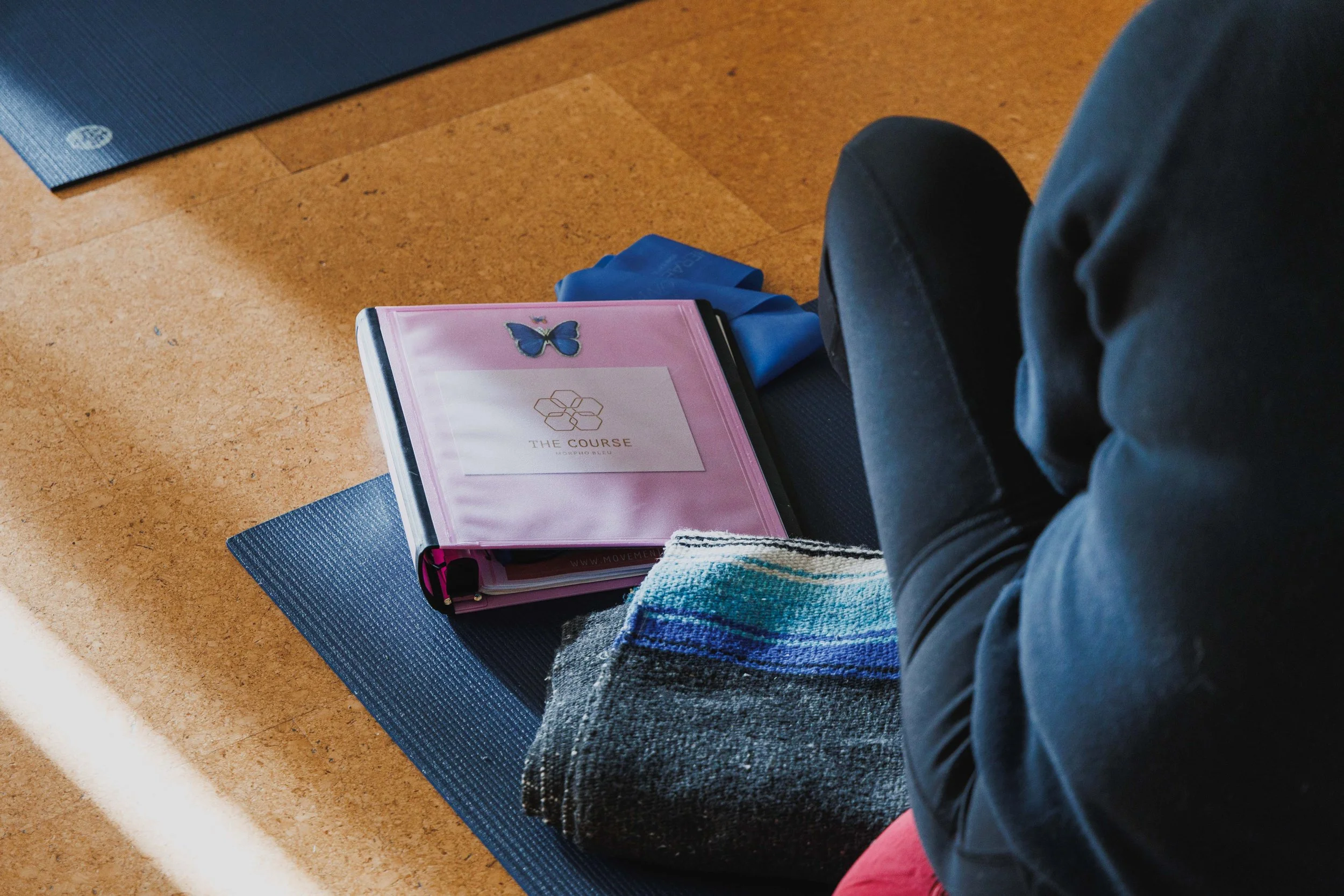Yoga teacher training manual on a yoga mat