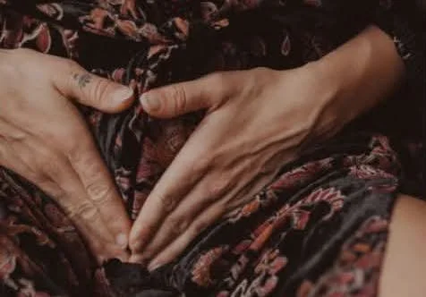 A woman's hands holding her womb