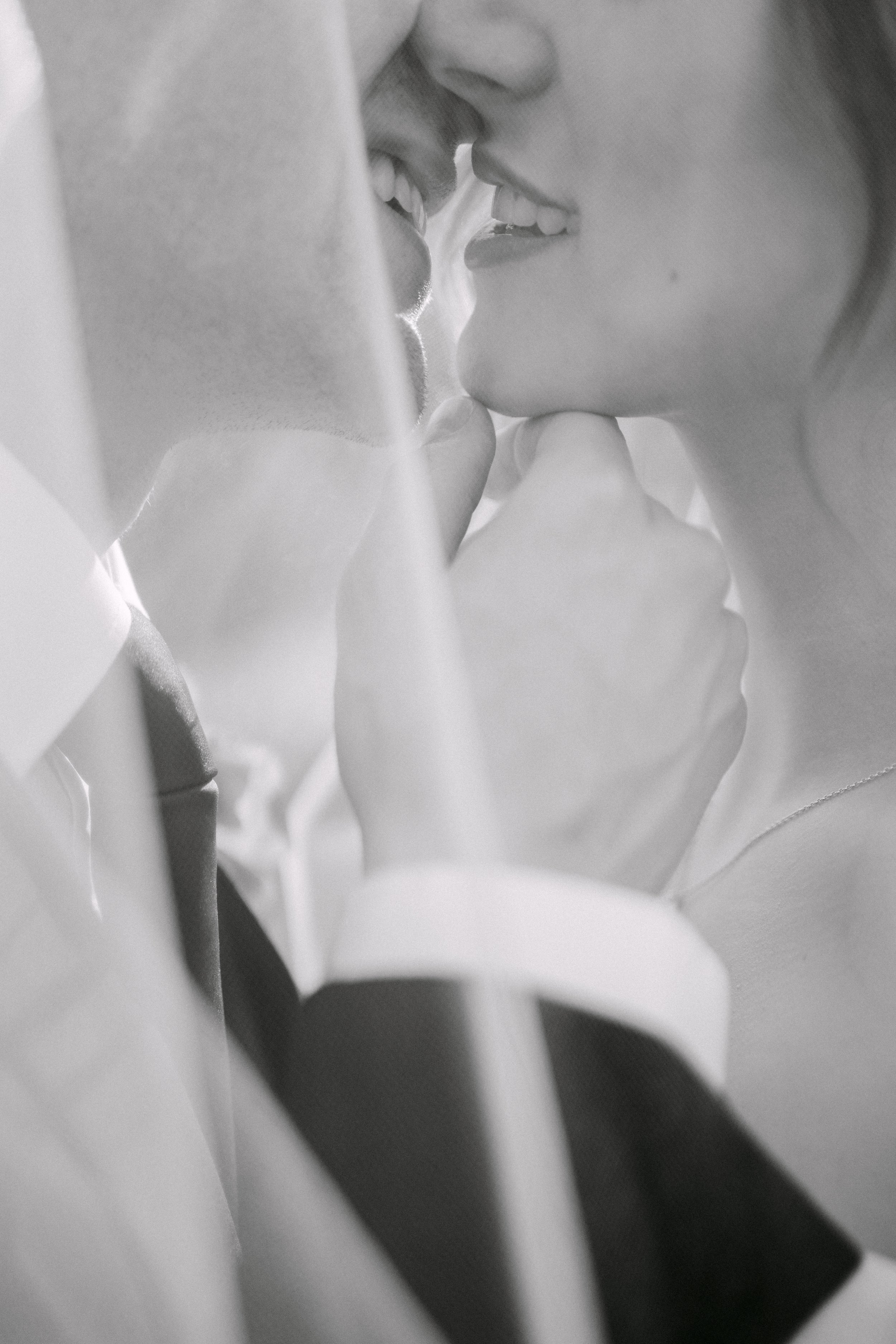 Close-up of a man and woman about to kiss, with their faces very close to each other, in black and white.