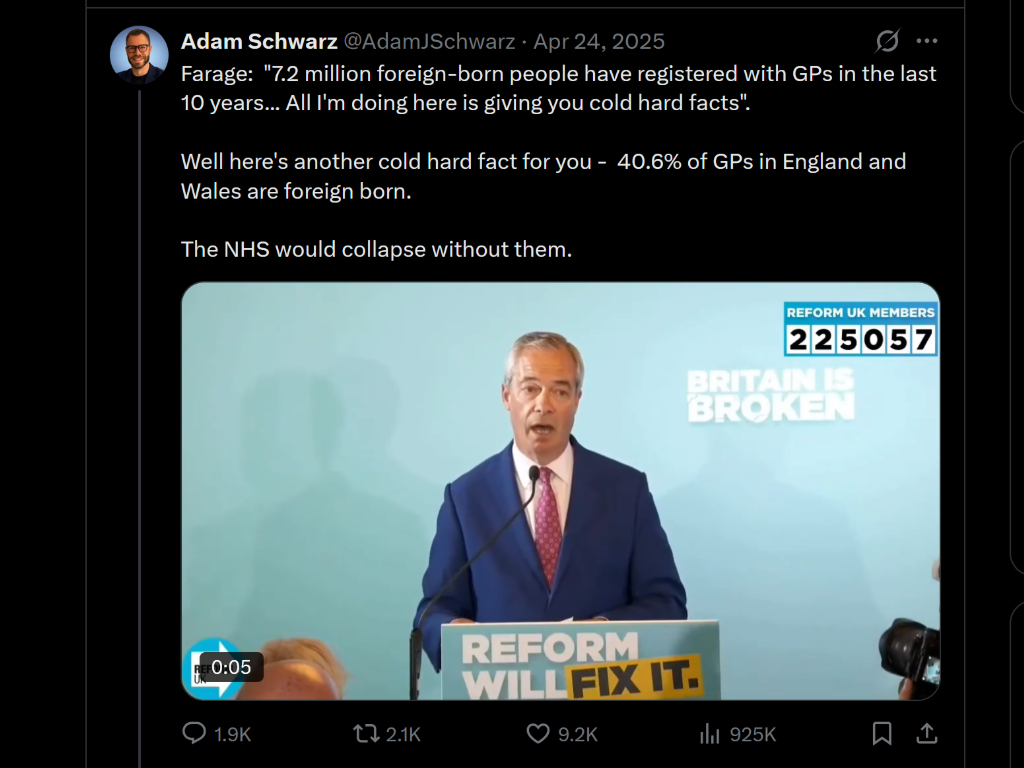 A man in a blue suit and pink tie speaking at a podium with a background poster that says "RE4ORM WILL FIX IT". The background includes a slogan "BRITAIN IS BROKEN" and a label for "REFORM UK MEMBERS" with a number 225057. The man is speaking into a 