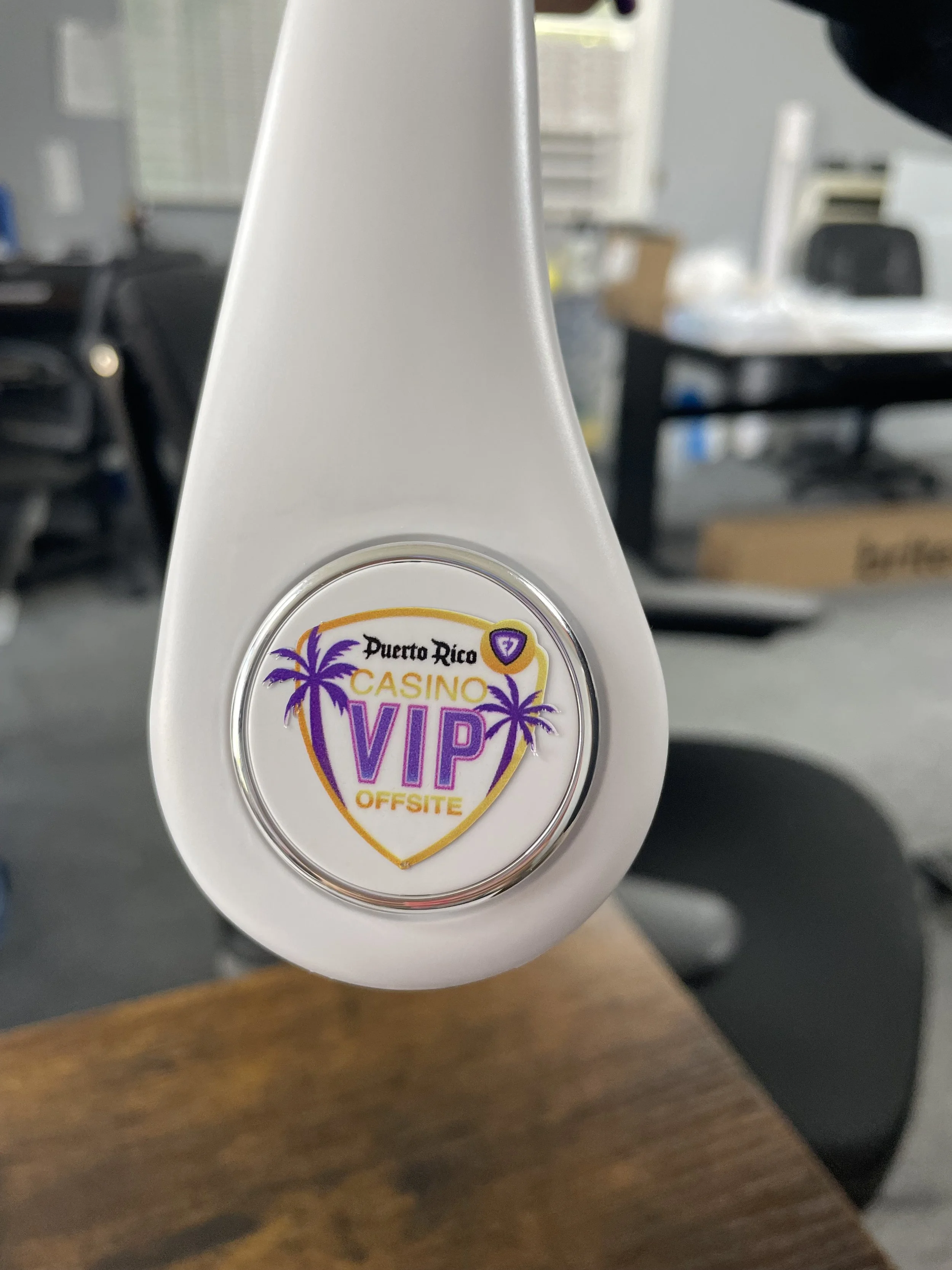 Close-up of a white object with a sticker that reads 'Puerto Rico Casino VIP Offsite' with purple and yellow design, including palm trees.