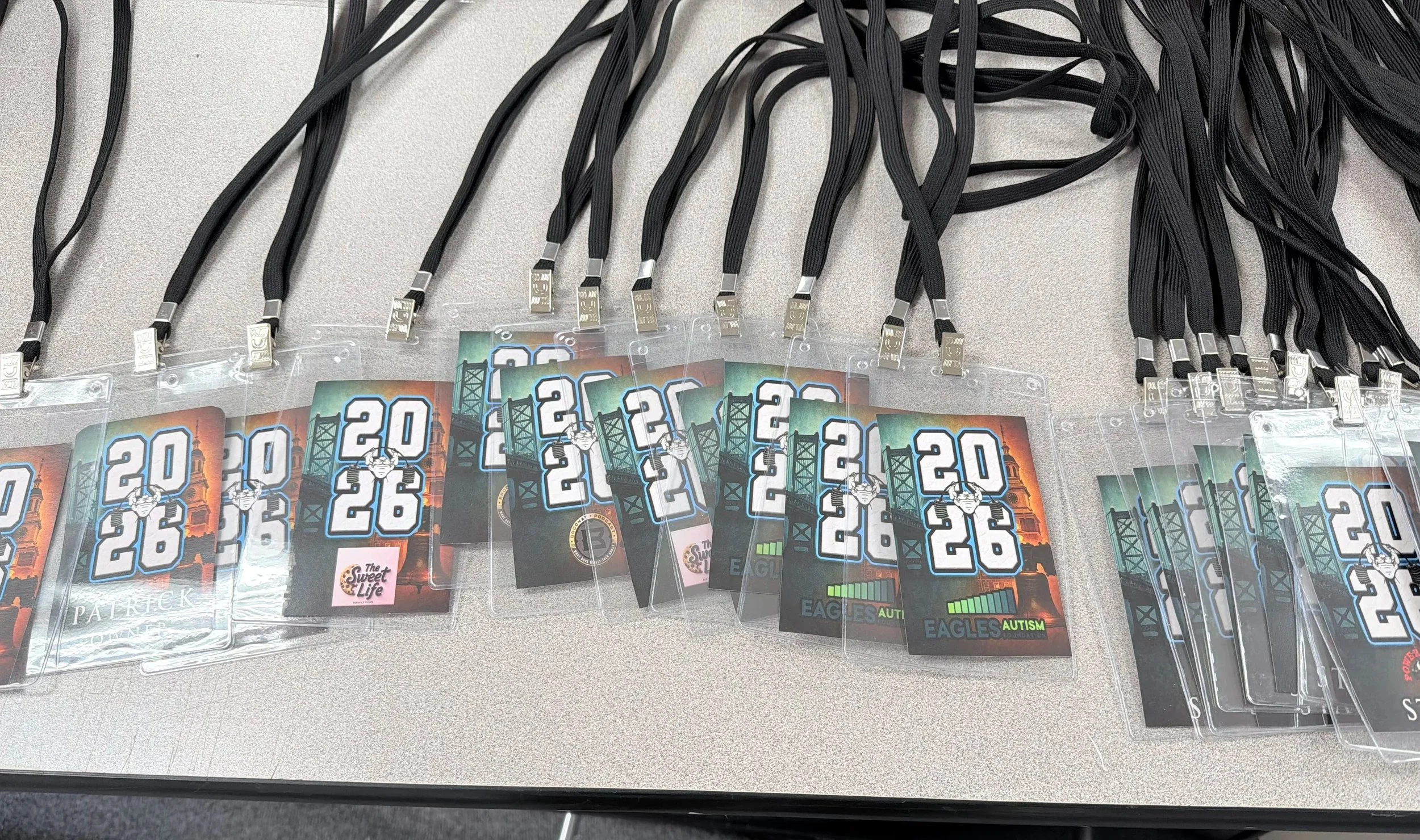Multiple conference name badges with black lanyards arranged on a table.