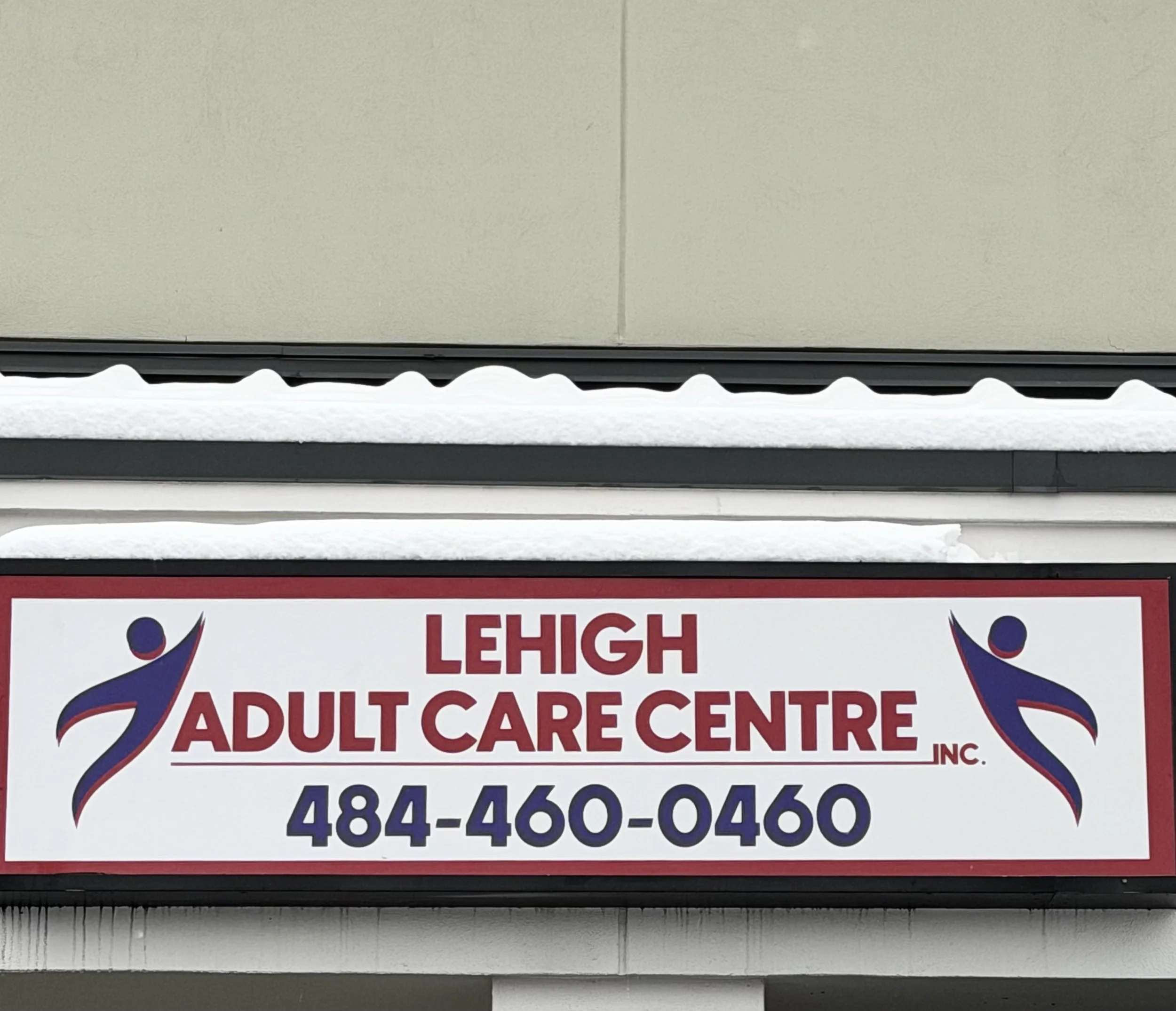 Sign for Lehigh Adult Care Centre with phone number 484-460-0460 and two abstract human figures on either side.