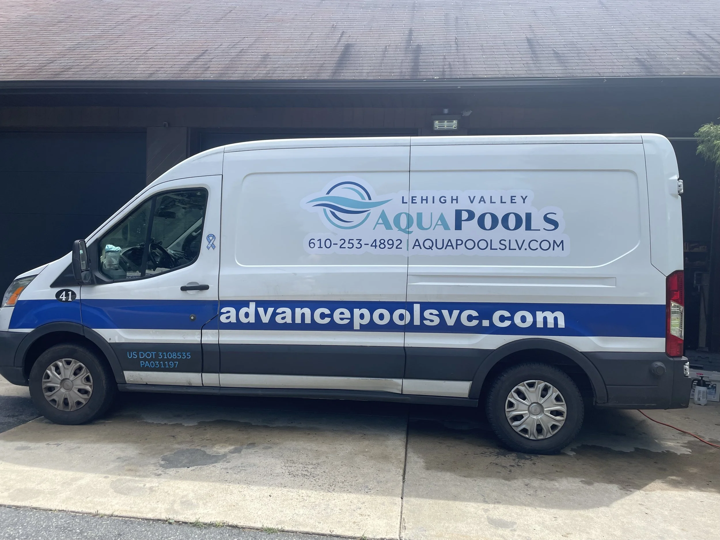 White service van with blue and teal lettering and graphics for Lehigh Valley Aqua Pools. It displays the company's website, phone number, and branding for pool installation and maintenance.