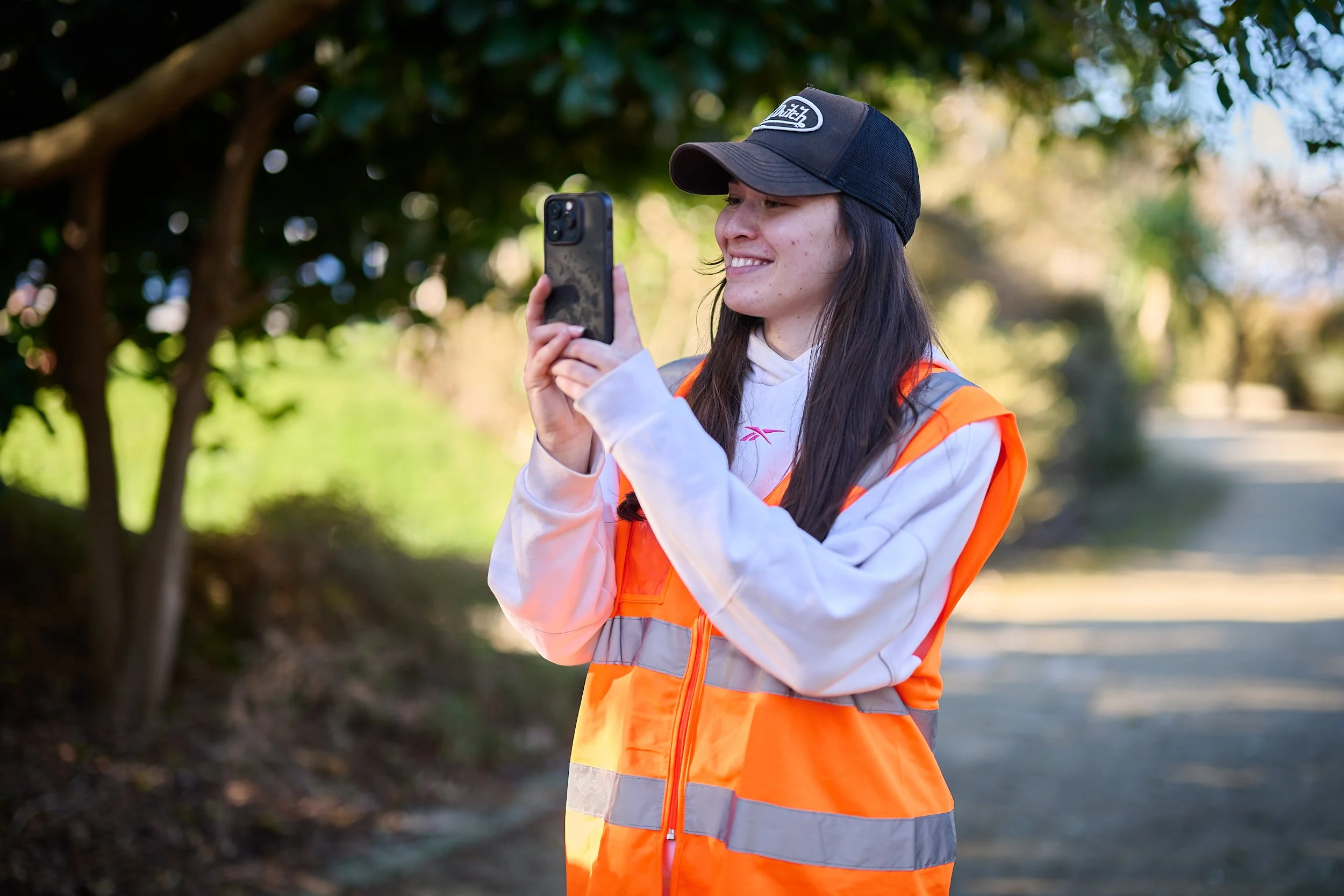Grace Bush filming behind the scenes on her phone for the Statistics New Zealand commercial 'Data Helps Us Do' in nature