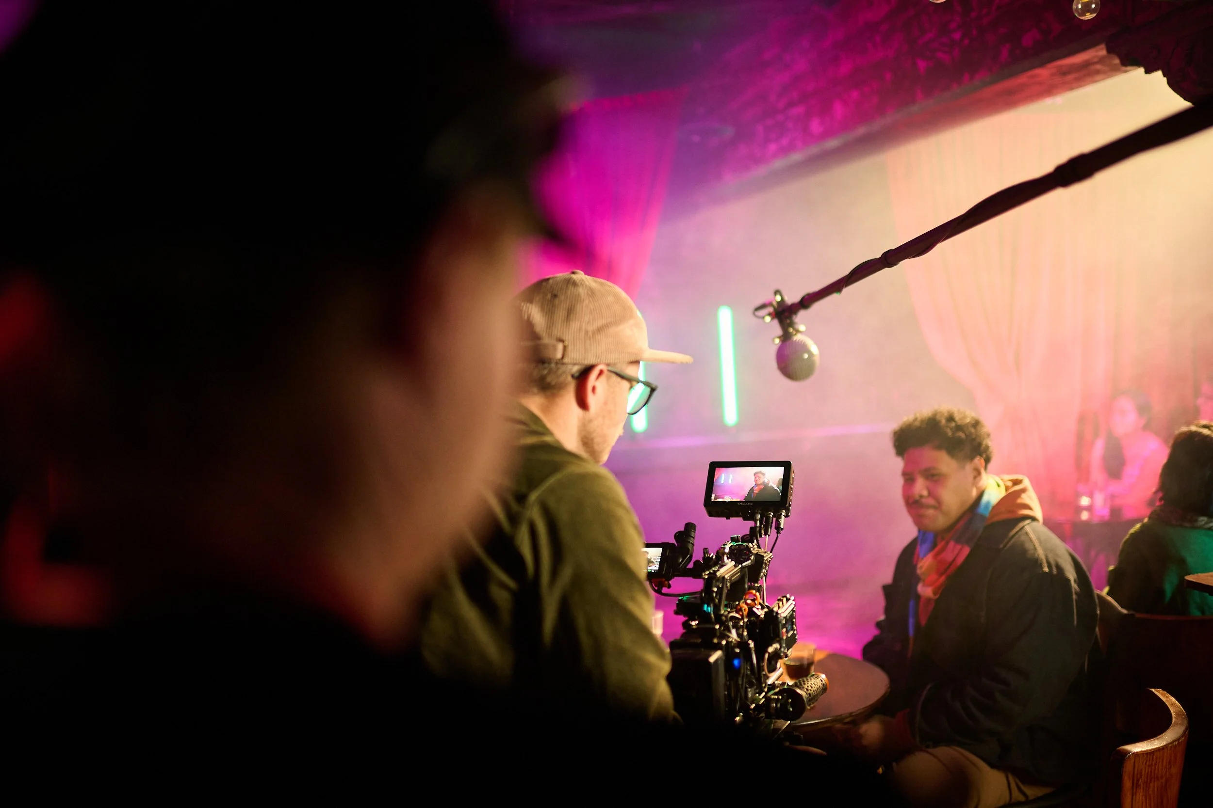 Camera operator Hamish McCormick filming the Statistics New Zealand commercial 'Data Helps Us Do' in a purple lit up bar