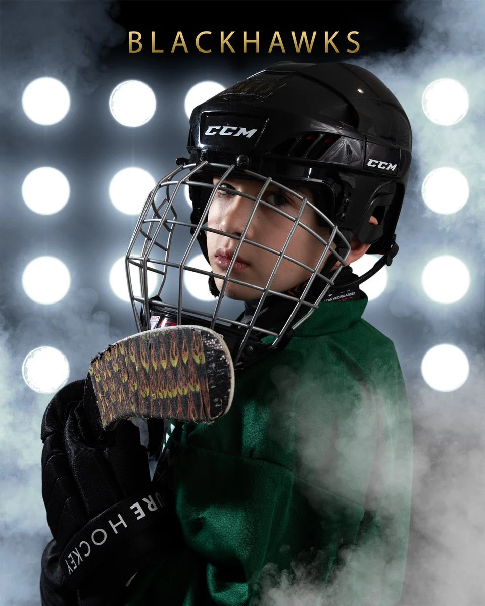 A young hockey player wearing a black CCM helmet, a green jersey, and black gloves, holding a hockey stick, with a foggy, illuminated background and the word 'BLACKHAWKS' at the top.