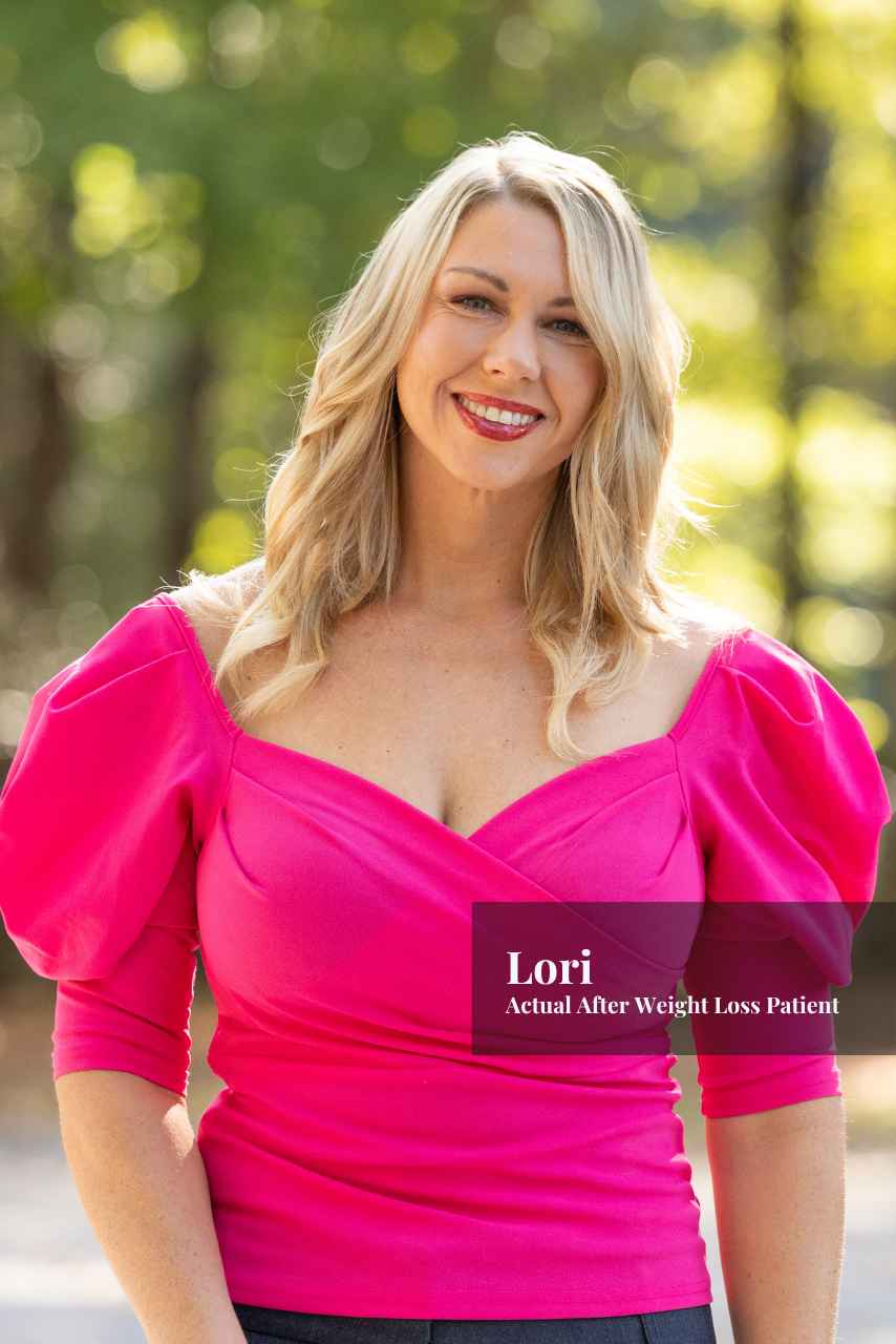 A woman with blonde hair, smiling, wearing a bright pink dress with puffed sleeves, outdoors with a blurred natural background of trees and sunlight.