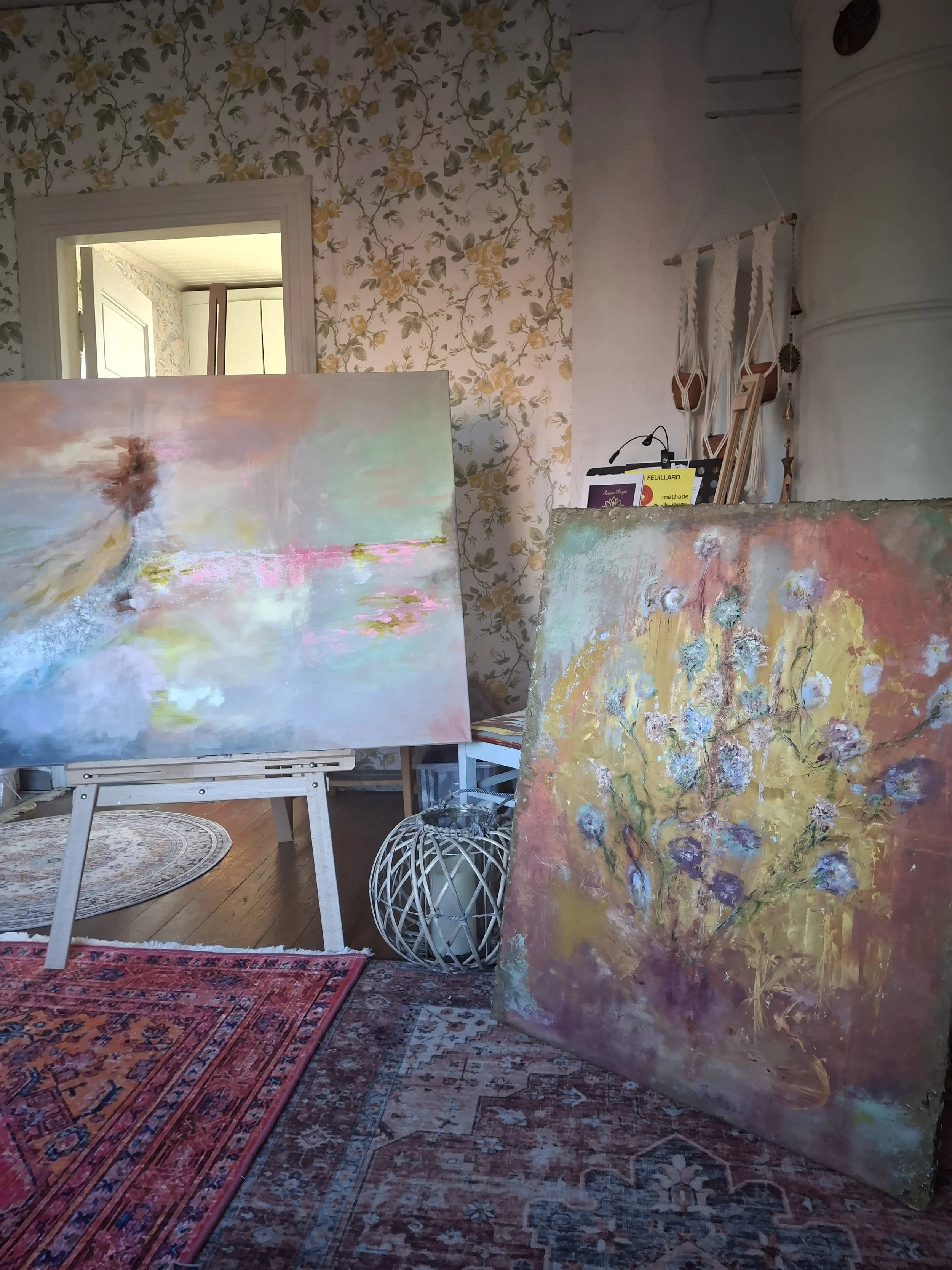 Kuvassa taideateljeehuone, jossa on erilaisia maalauksia ja värikkäitä tauluja. 100 vuotta vanha kaunis ateljee. Abstrakteja maalauksia. Akryylimaalauksia. Acrylic paintings. Artwork. Abstract Art. Beautiful old Atelier. Keltaisia ruusuja tapetissa.