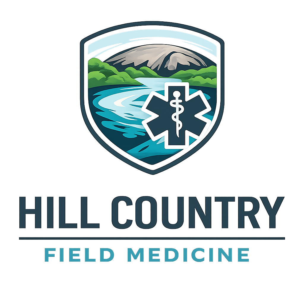 A logo for Hill County Field Medicine featuring a mountain, river, and trees within a shield, with a medical symbol inside the shield, and the text Hill County Field Medicine below.