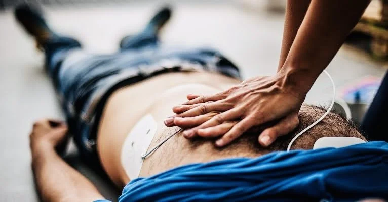 Person receiving chest compressions during CPR from a healthcare provider.