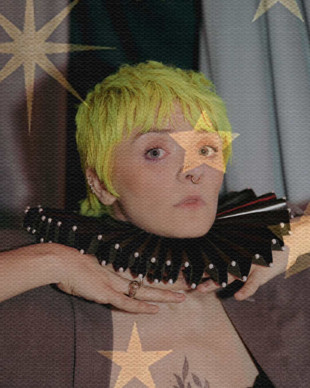 A lesbian portrait with a star-like overlay. The person has short neon hair and is wearing a black clown collar. They have a whimsical expression across their face.