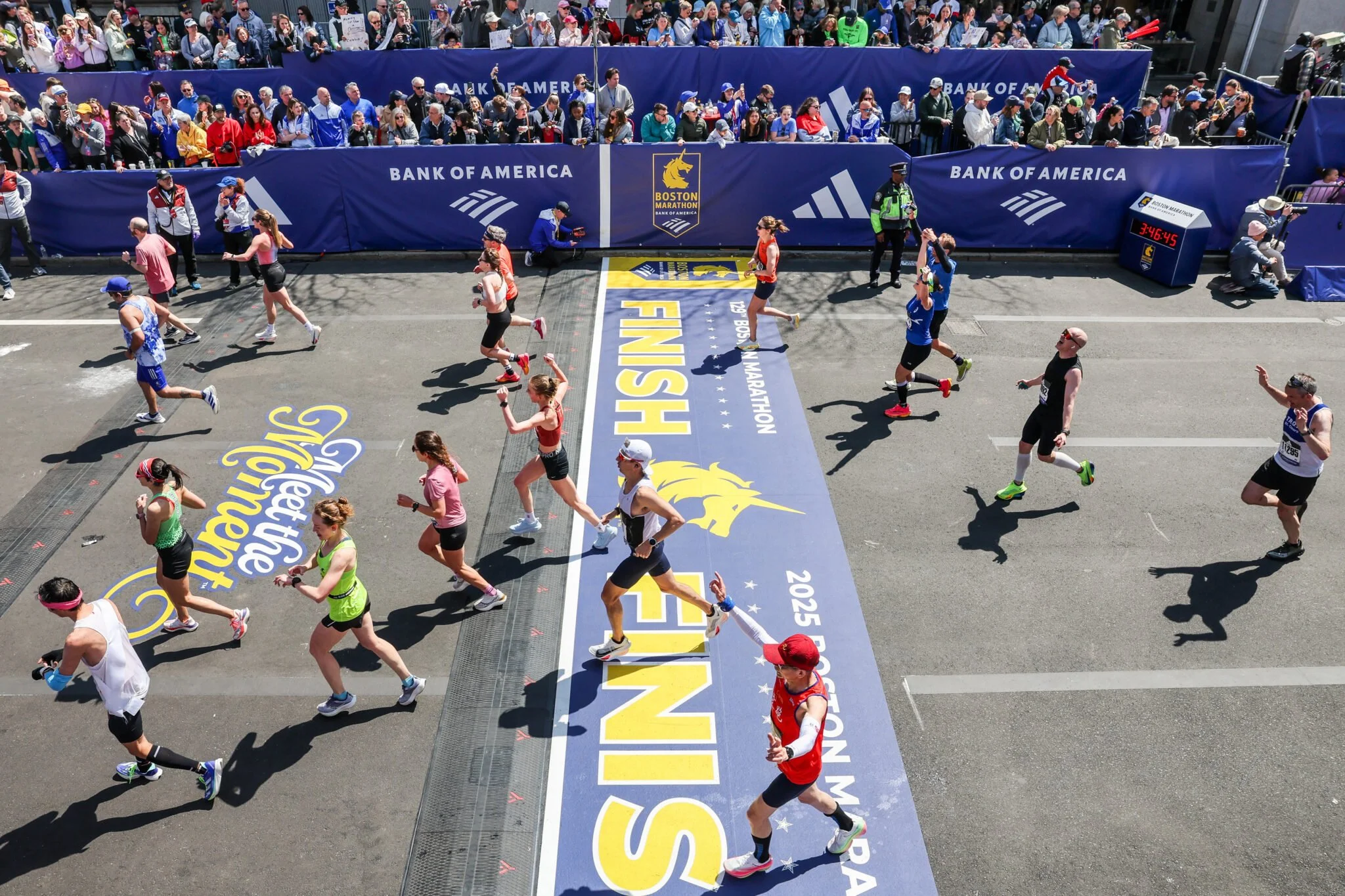 runners crossing the boston marathon finishline