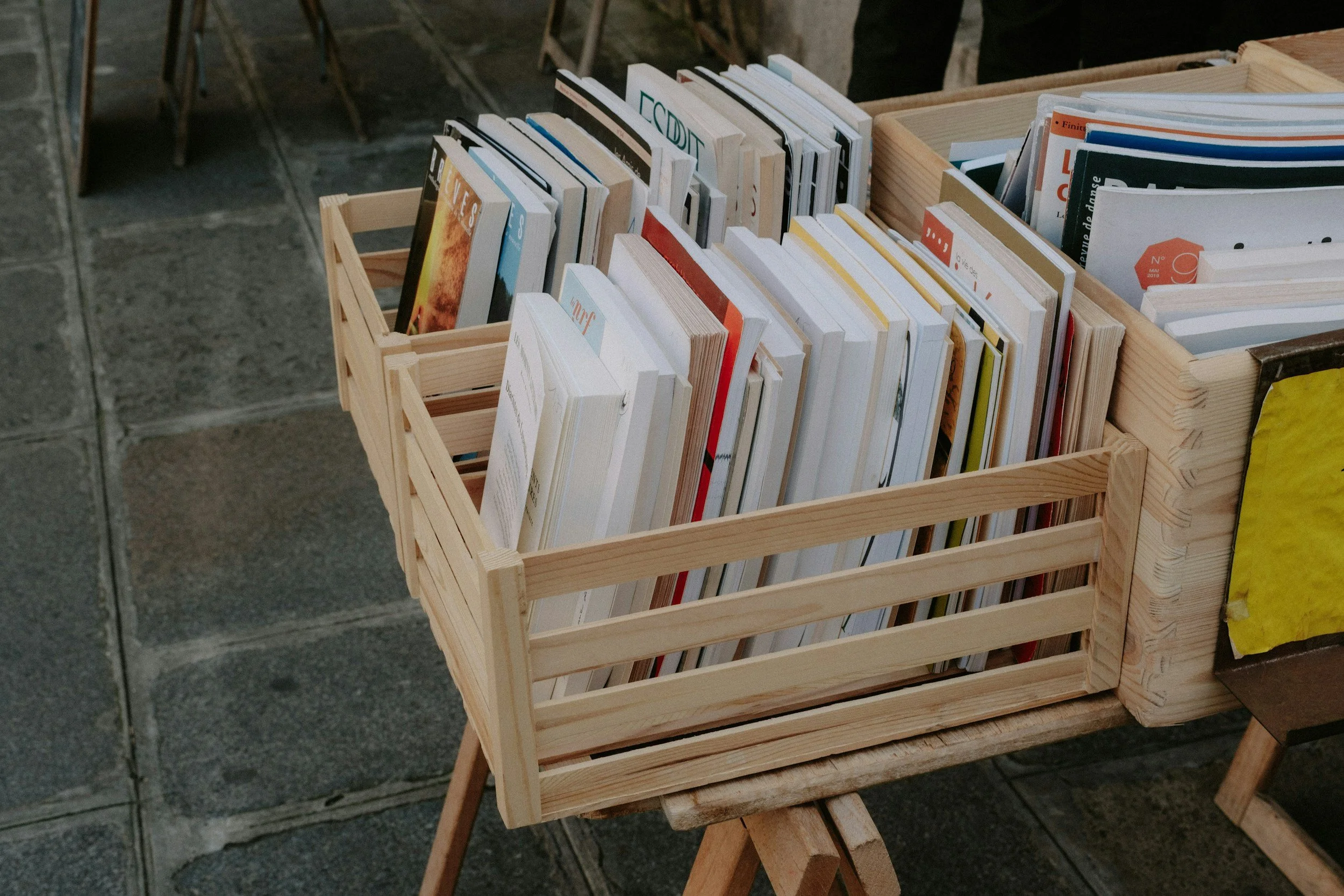 Wooden crate filled with various books in a display