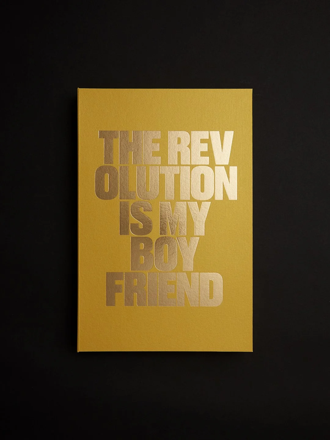 Yellow card with words cut out that read, "The Revolution is My Boyfriend" in gold }