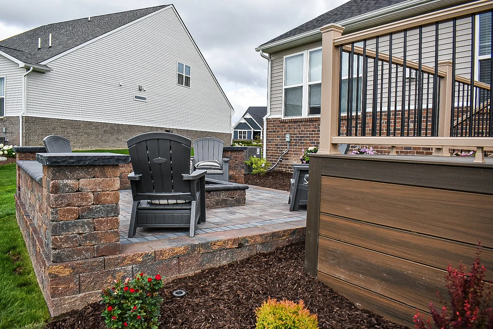 Outdoor living area with a gas fire pit installation surrounded by premium paver patio construction — GLC Lawn & Landscape