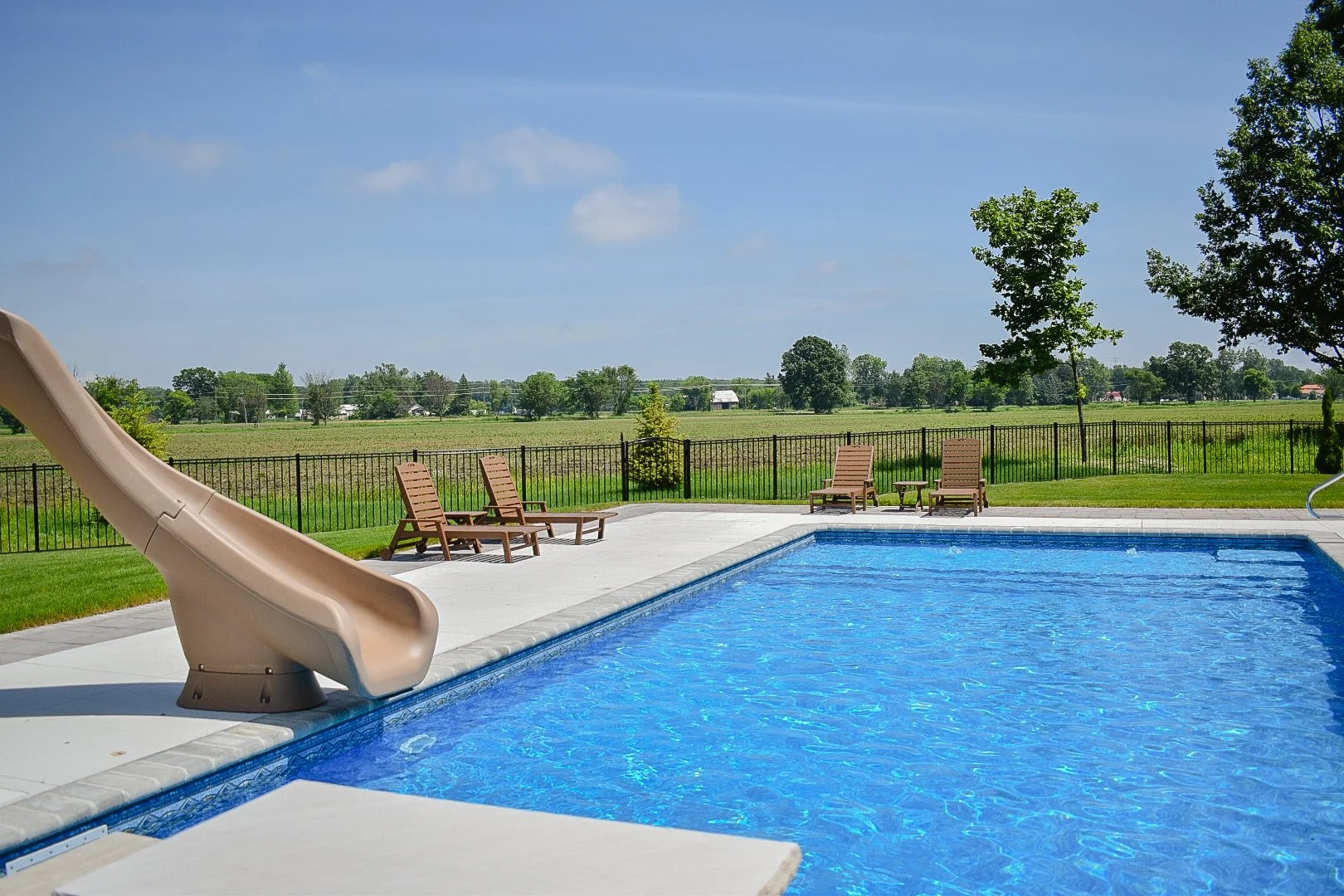 Pool slide integration adding fun and functionality to a professionally designed backyard retreat — GLC Lawn & Landscape