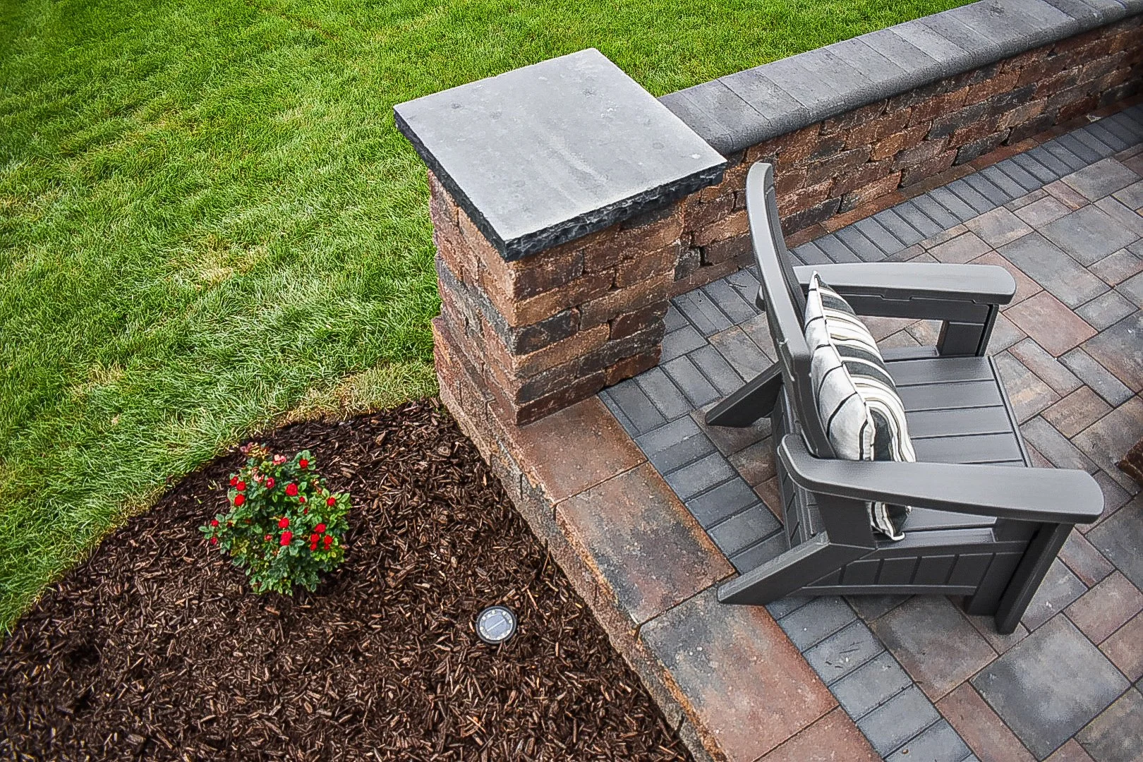 Landscape bed installation with colorful plantings designed to complement a custom paver patio and outdoor living area — GLC Lawn & Landscape