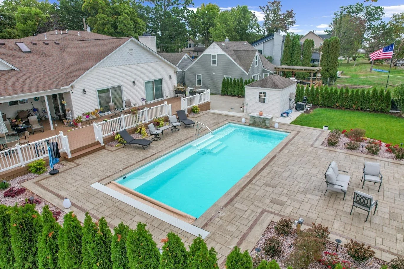 A backyard featuring fiberglass pool, paver patio, and landscape design in Canton, MI
