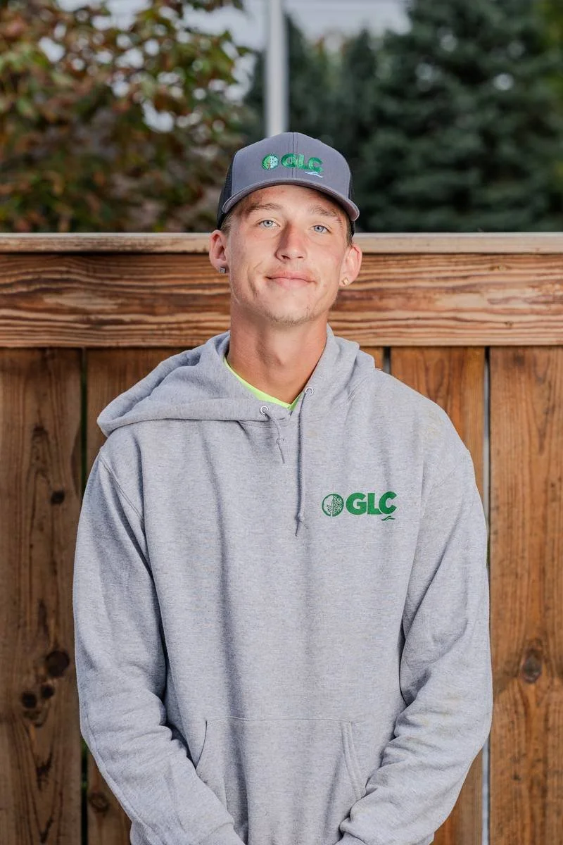 Logan, Landscape Specialist, in a gray GLC hoodie and cap — GLC Landscaping & Pools