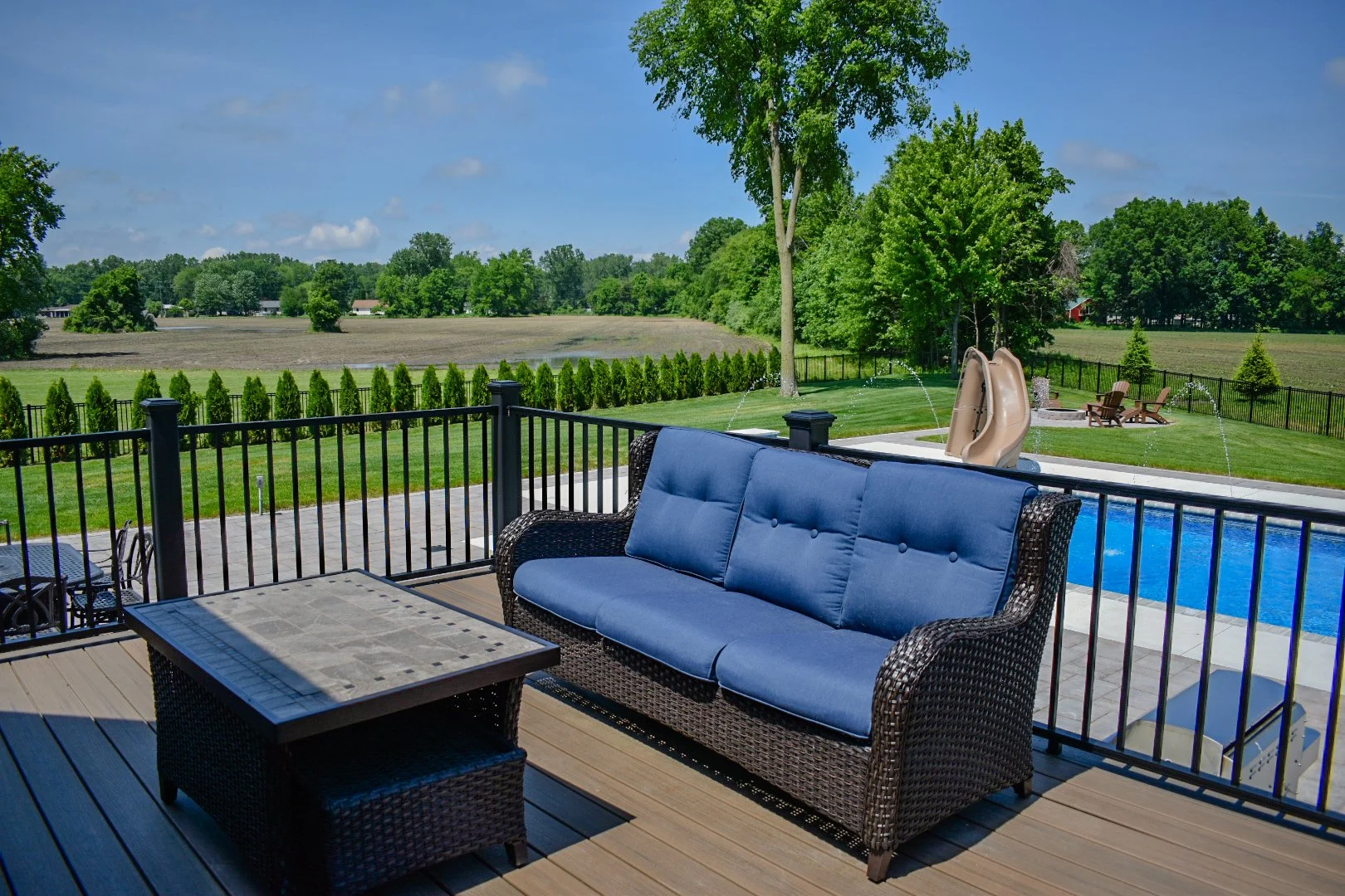 Pool slide integration alongside large-format paver patio construction for a complete family-friendly outdoor environment — GLC Lawn & Landscape