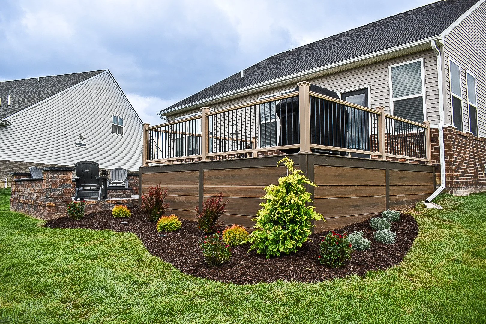 Raised deck integration connecting indoor and outdoor living areas with custom hardscape features — GLC Lawn & Landscape